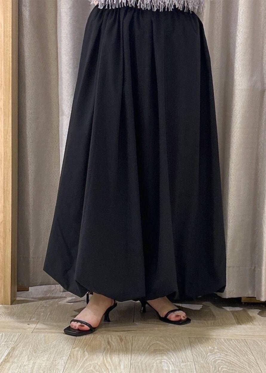 ブラック系のサンダル、ブラック系のスカート、グレー系のタンクトップを着用したレディースの夏コーディネートの5枚目の写真