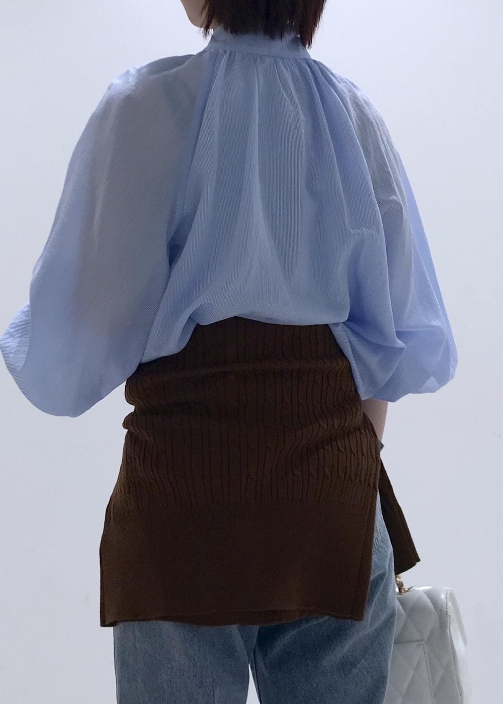 ブラック系のバレエシューズ、ブラウン系のカーディガン/ボレロ、ホワイト系のショルダーバッグを着用したレディースの冬コーディネートの7枚目の写真