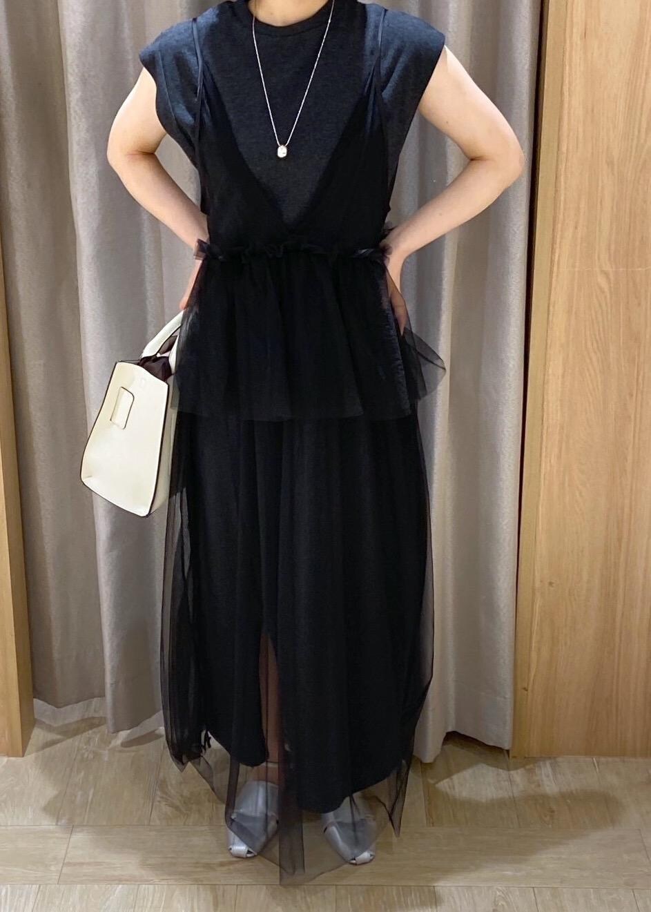 シルバー系のサンダル、ホワイト系のハンドバッグ、ブラック系のワンピースを着用したレディースの夏コーディネートの5枚目の写真