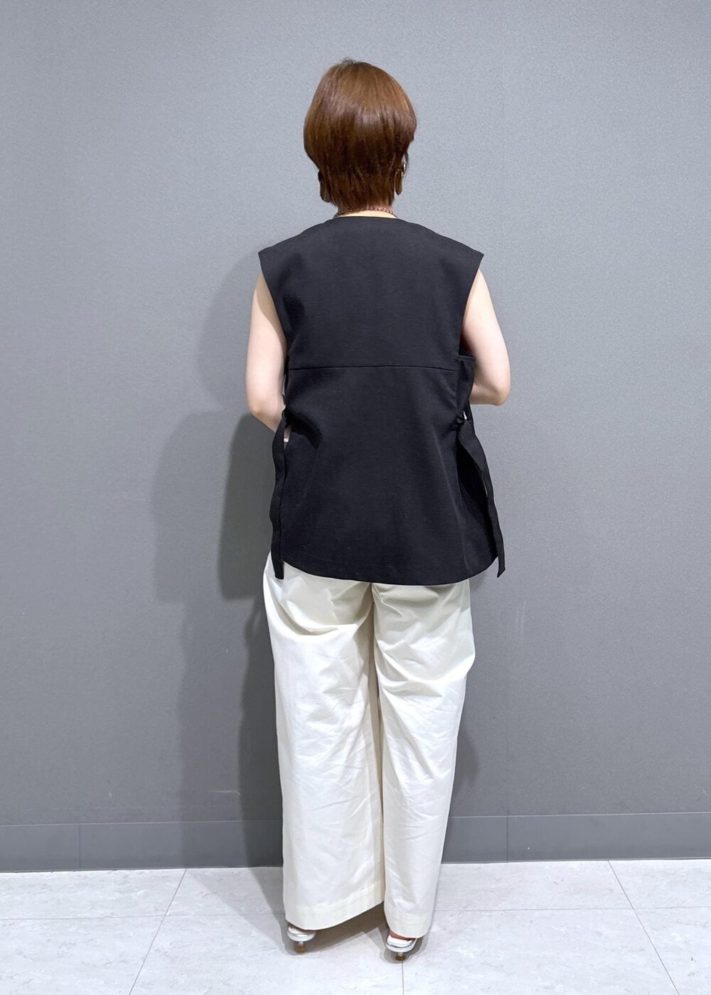 シルバー系のパンプス、レッド系のタンクトップ、ホワイト系のその他パンツを着用したレディースの夏コーディネートの4枚目の写真
