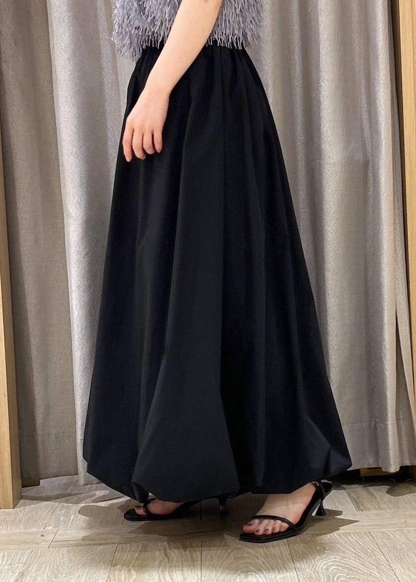 ブラック系のサンダル、ブラック系のスカート、グレー系のタンクトップを着用したレディースの夏コーディネートの6枚目の写真