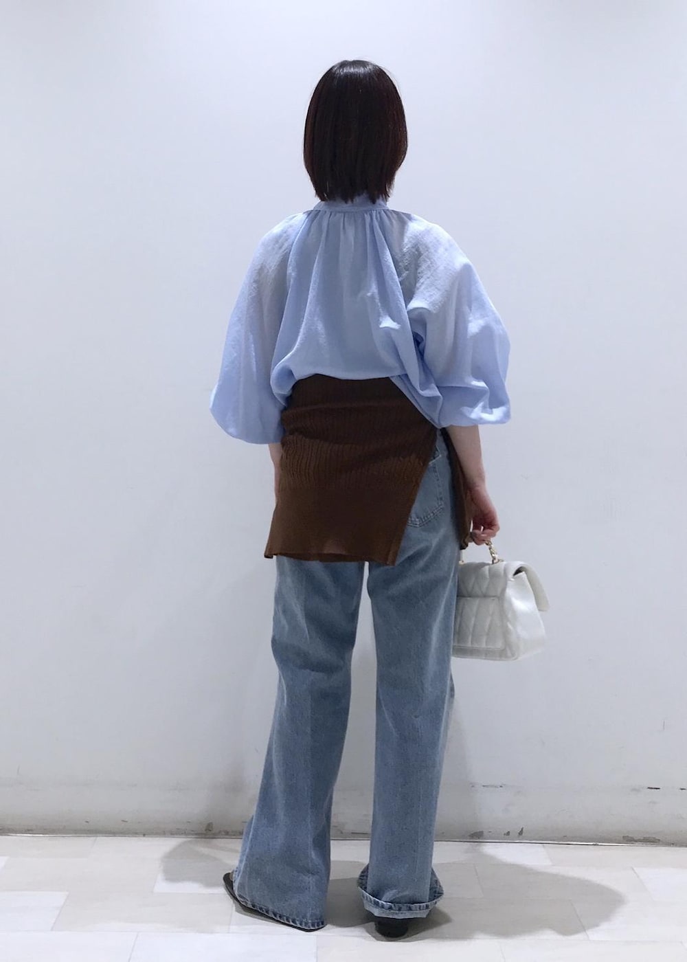 ブラック系のバレエシューズ、ブラウン系のカーディガン/ボレロ、ホワイト系のショルダーバッグを着用したレディースの冬コーディネートの4枚目の写真