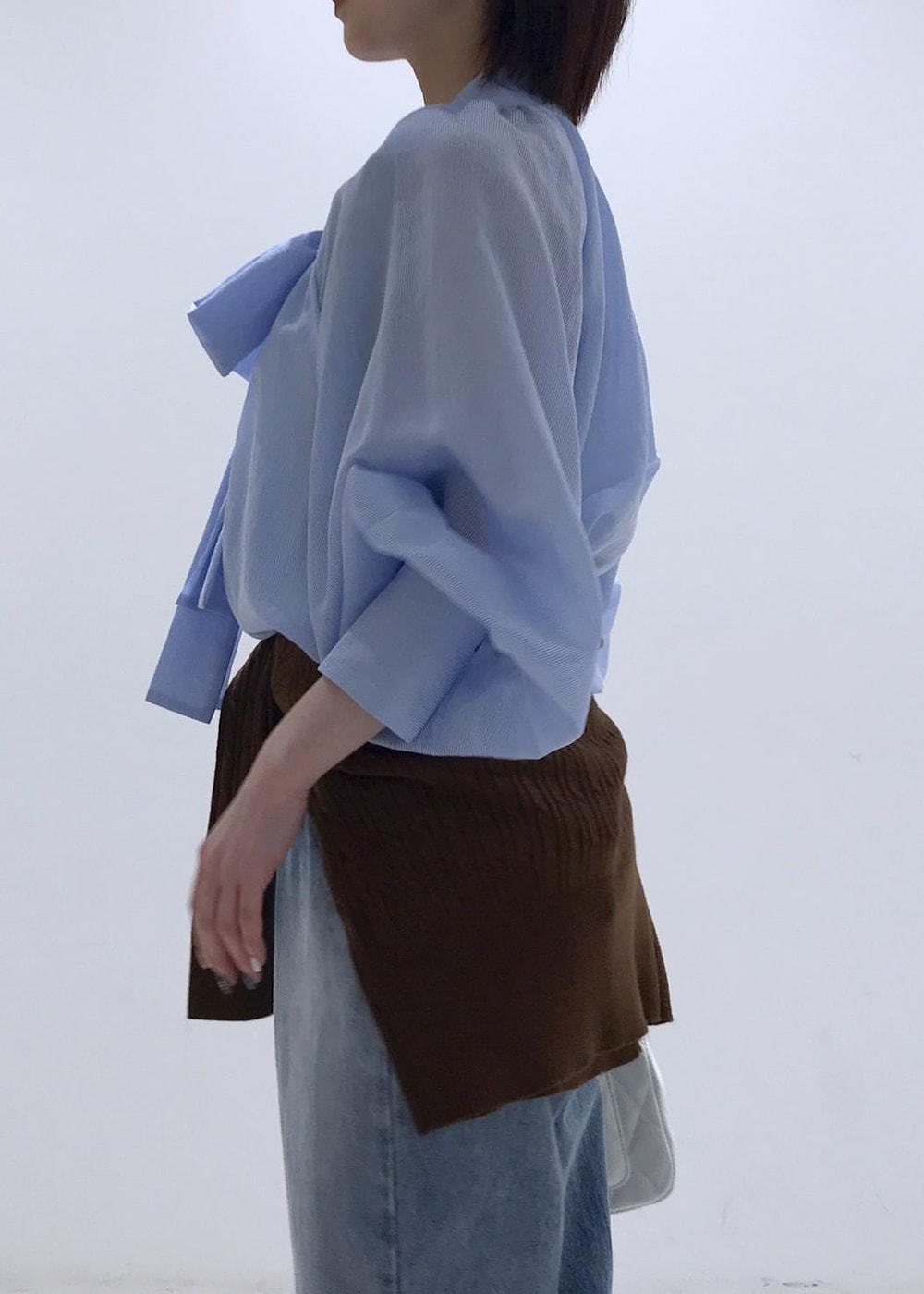 ブラック系のバレエシューズ、ブラウン系のカーディガン/ボレロ、ホワイト系のショルダーバッグを着用したレディースの冬コーディネートの6枚目の写真