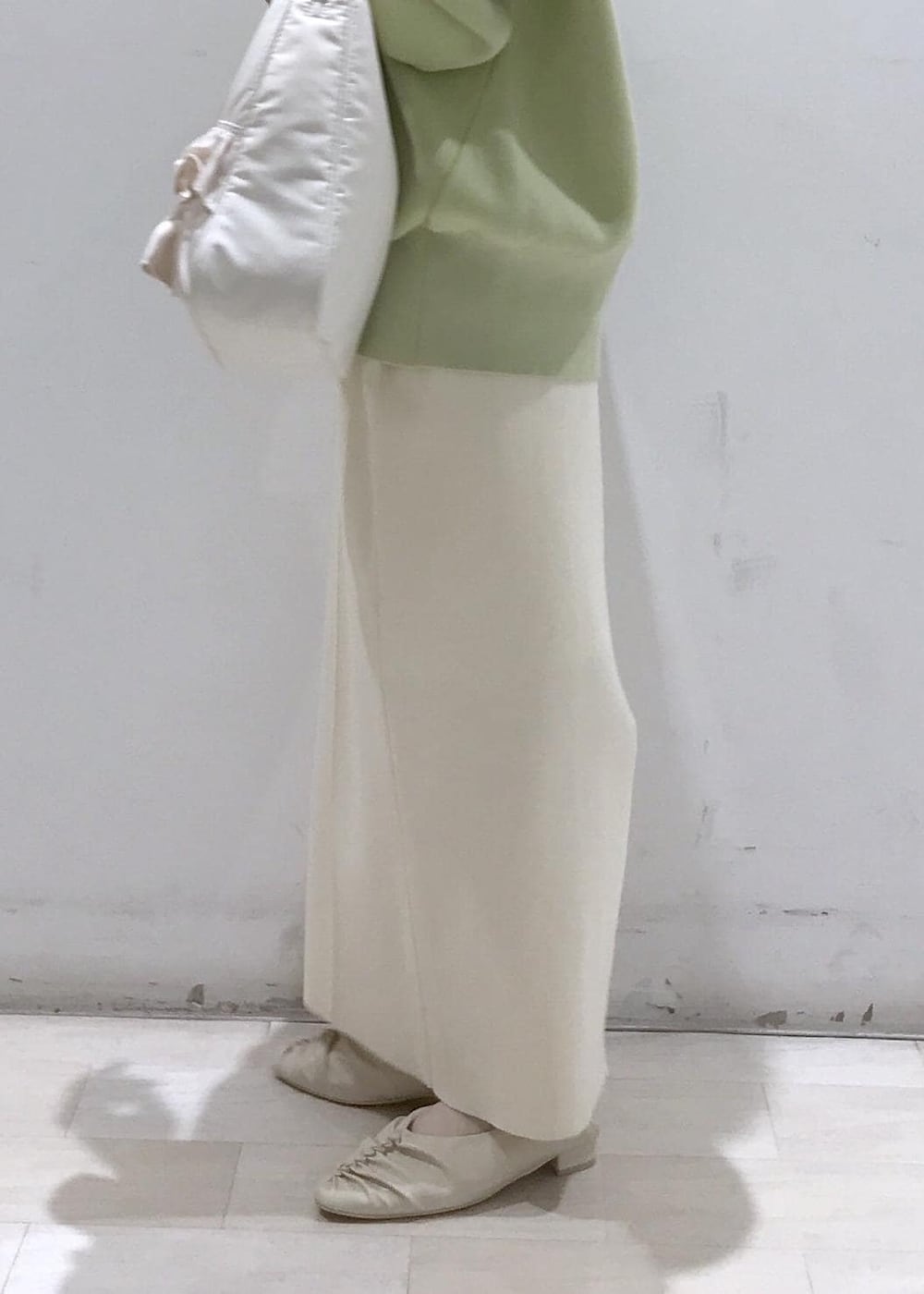 ホワイト系のパンプス、ホワイト系のシャツ/ブラウス、グリーン系のカーディガン/ボレロを着用したレディースの冬コーディネートの9枚目の写真