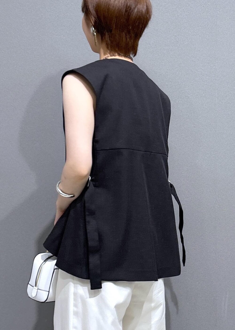 シルバー系のパンプス、レッド系のタンクトップ、ホワイト系のその他パンツを着用したレディースの夏コーディネートの7枚目の写真