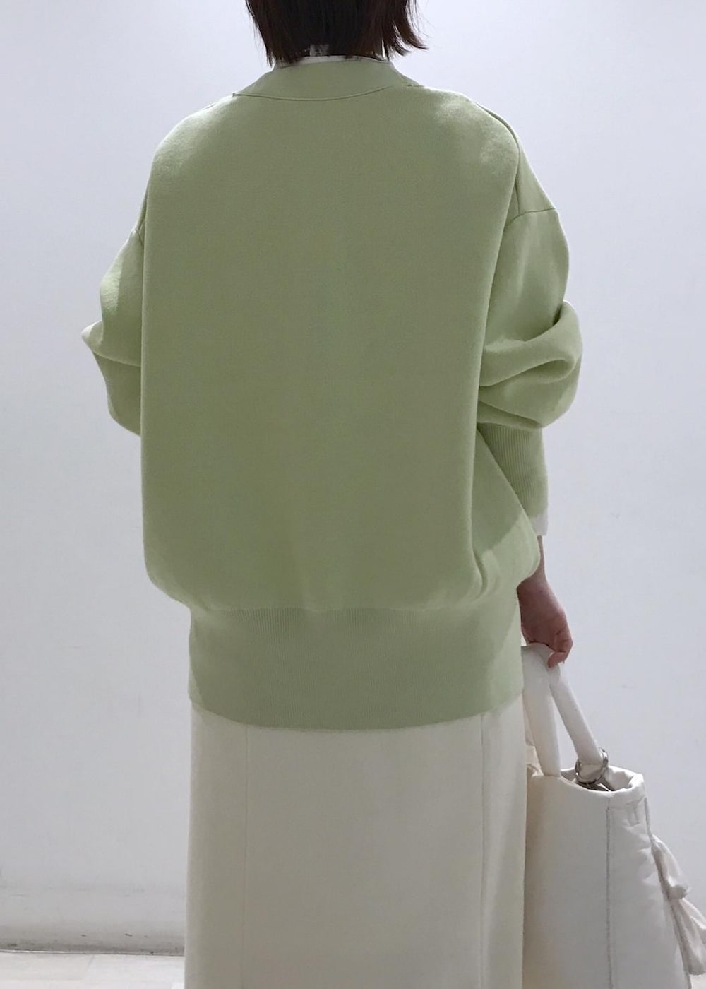 ホワイト系のパンプス、ホワイト系のシャツ/ブラウス、グリーン系のカーディガン/ボレロを着用したレディースの冬コーディネートの7枚目の写真