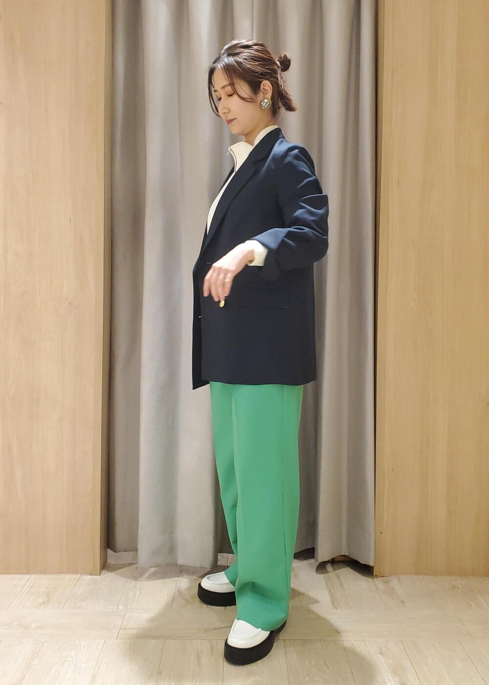 ホワイト系のローファー、ホワイト系のその他トップス、グリーン系のスラックスを着用したレディースの冬コーディネートの2枚目の写真