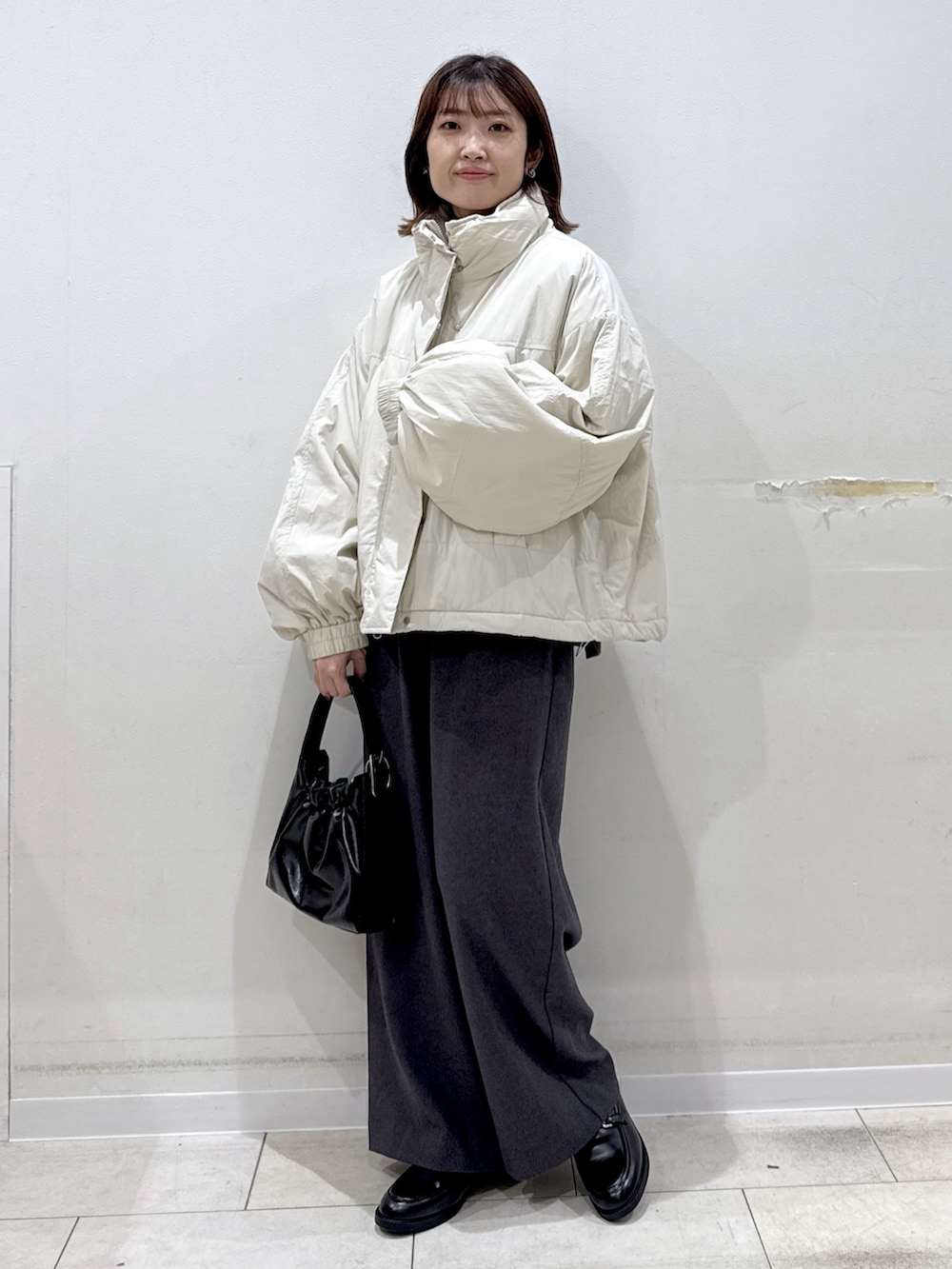 グレー系のその他パンツ、ブラック系のローファー、ホワイト系のその他アウターを着用したレディースの冬コーディネートの2枚目の写真