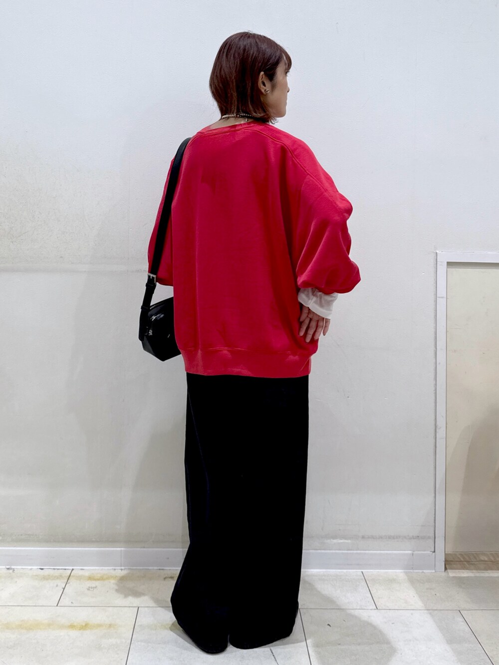 ホワイト系のTシャツ/カットソー、ブラック系のデニムパンツ、レッド系のスウェットを着用したレディースの秋コーディネートの3枚目の写真