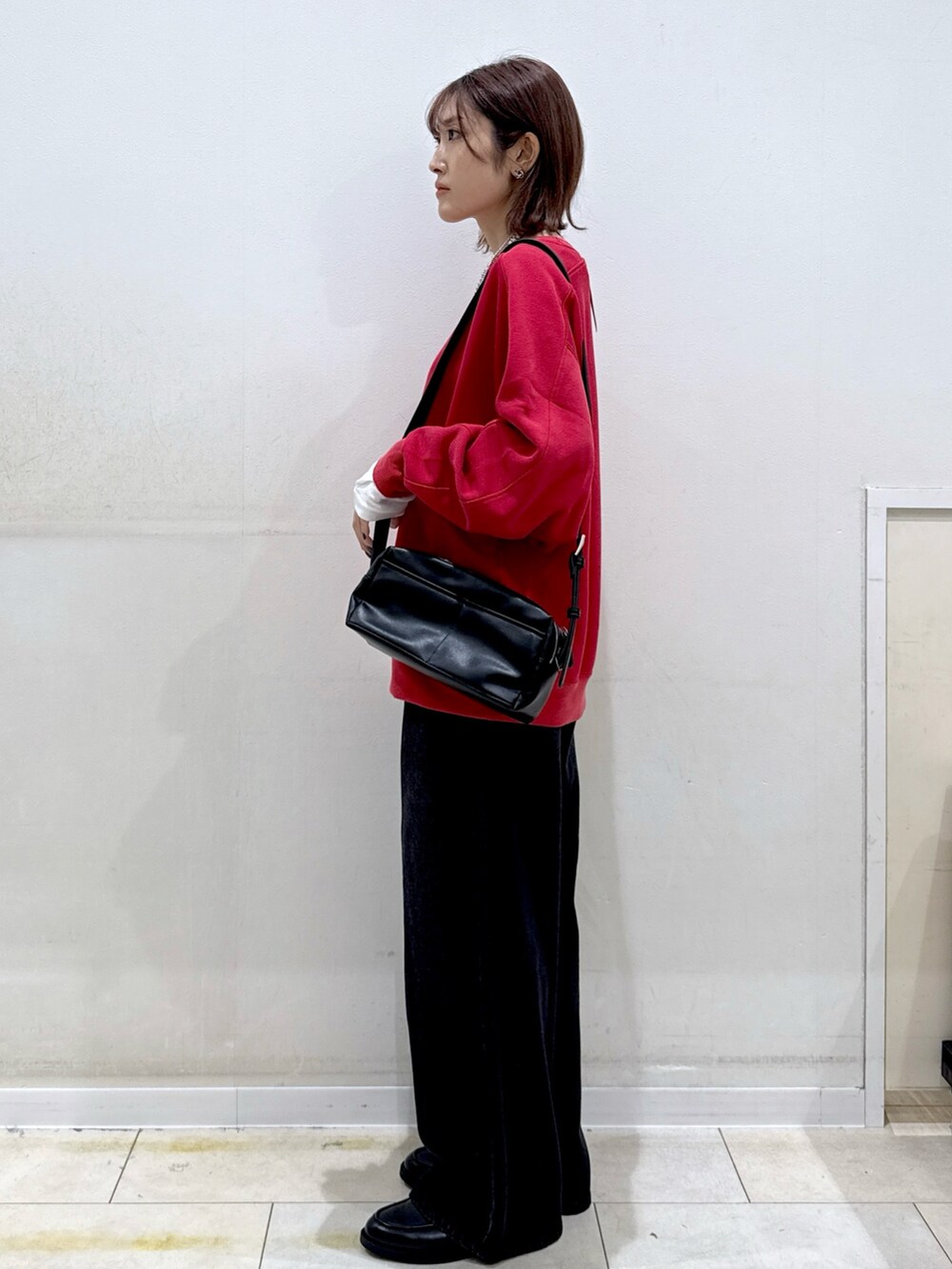 ホワイト系のTシャツ/カットソー、ブラック系のデニムパンツ、レッド系のスウェットを着用したレディースの秋コーディネートの2枚目の写真