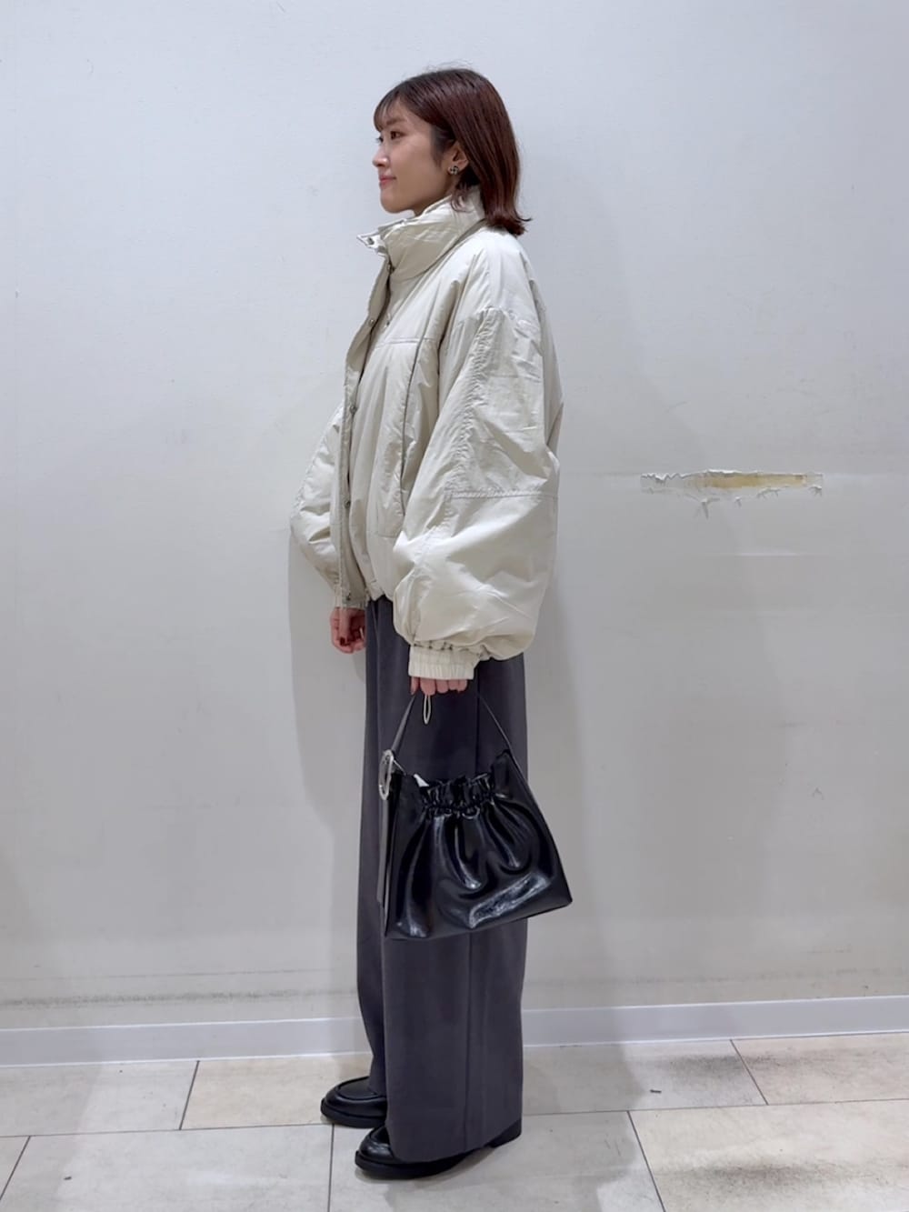 グレー系のその他パンツ、ブラック系のローファー、ホワイト系のその他アウターを着用したレディースの冬コーディネートの3枚目の写真