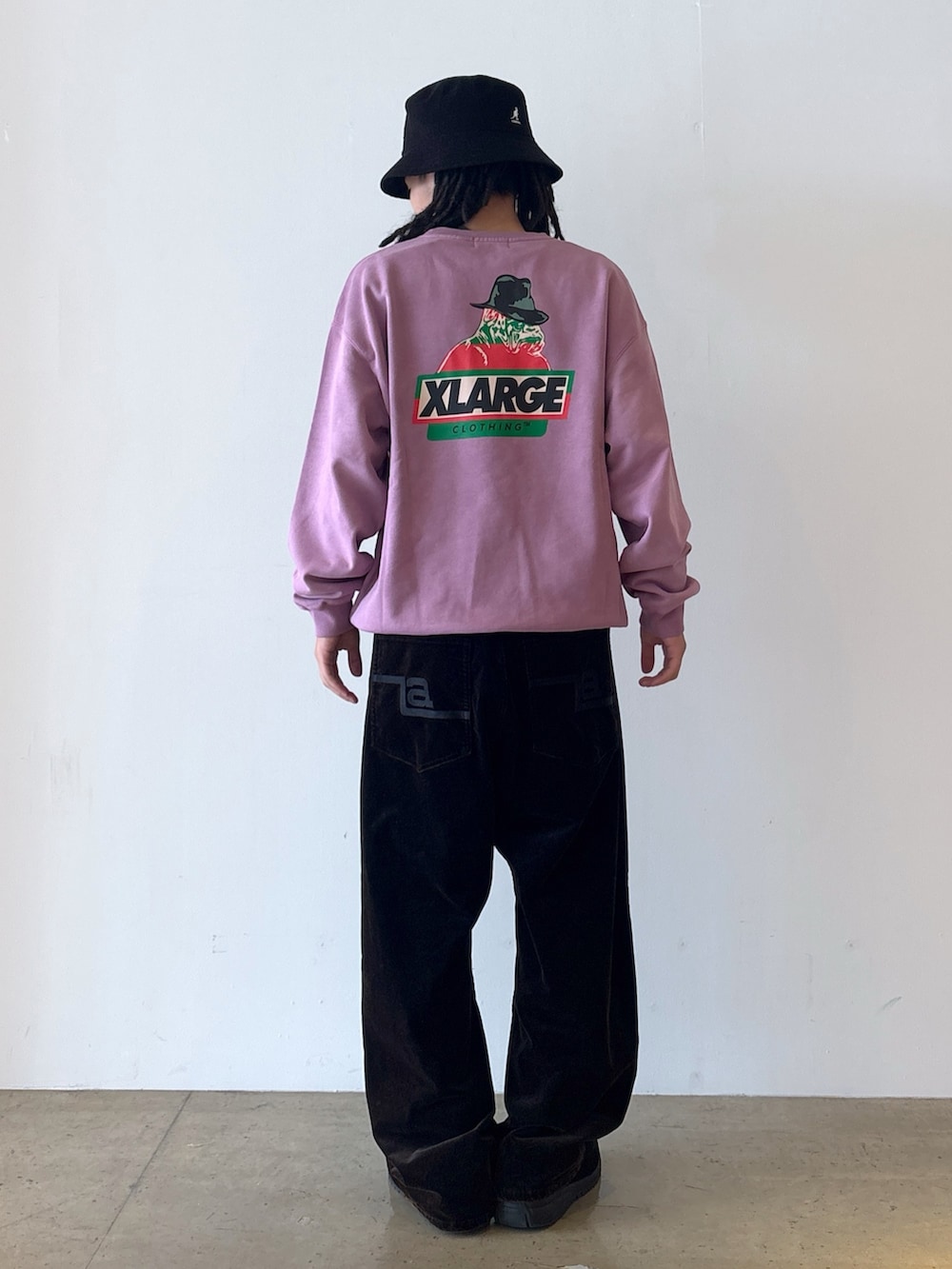 パープル系のスウェット、ブラック系のその他パンツ、ブラック系のハットを着用したメンズの秋コーディネートの3枚目の写真
