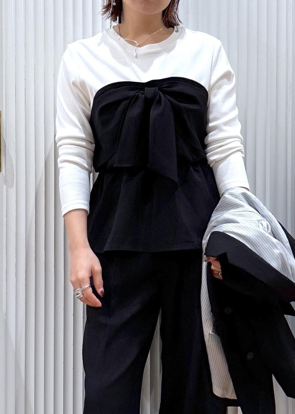 ブラック系のスラックス、ブラック系のテーラードジャケット、ブラック系のブーツを着用したレディースの秋コーディネートの6枚目の写真