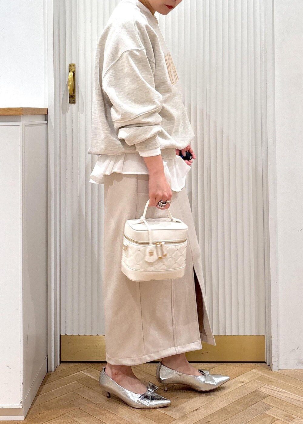 シルバー系のパンプス、ホワイト系のスウェット、ホワイト系のシャツ/ブラウスを着用したレディースの冬コーディネートの7枚目の写真