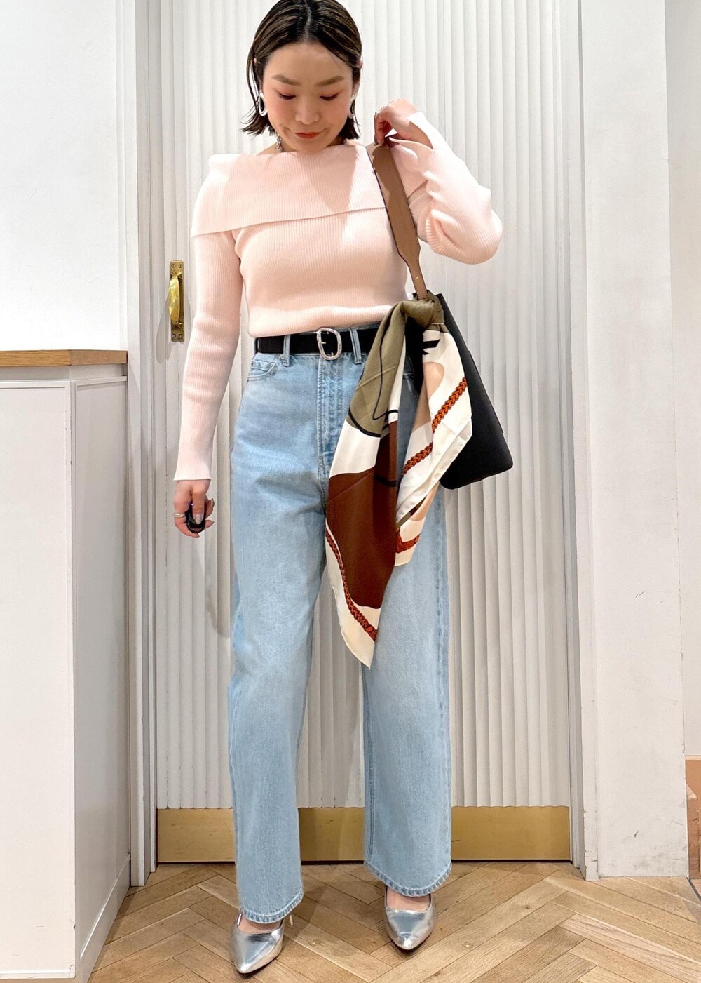 ブルー系のデニムパンツ、ブラック系のトートバッグ、ピンク系のニット/セーターを着用したレディースの春コーディネートの10枚目の写真