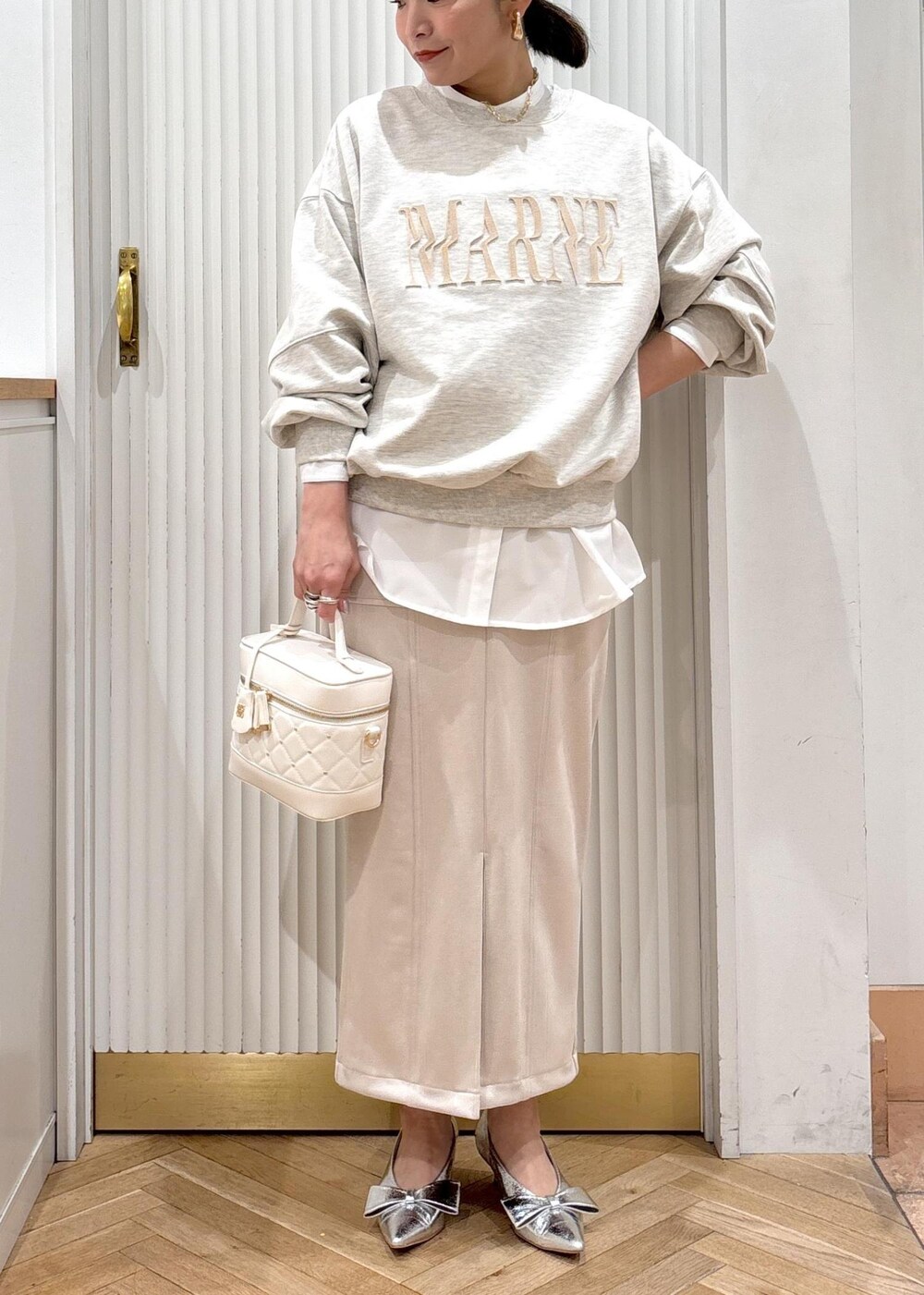 シルバー系のパンプス、ホワイト系のスウェット、ホワイト系のシャツ/ブラウスを着用したレディースの冬コーディネートの10枚目の写真