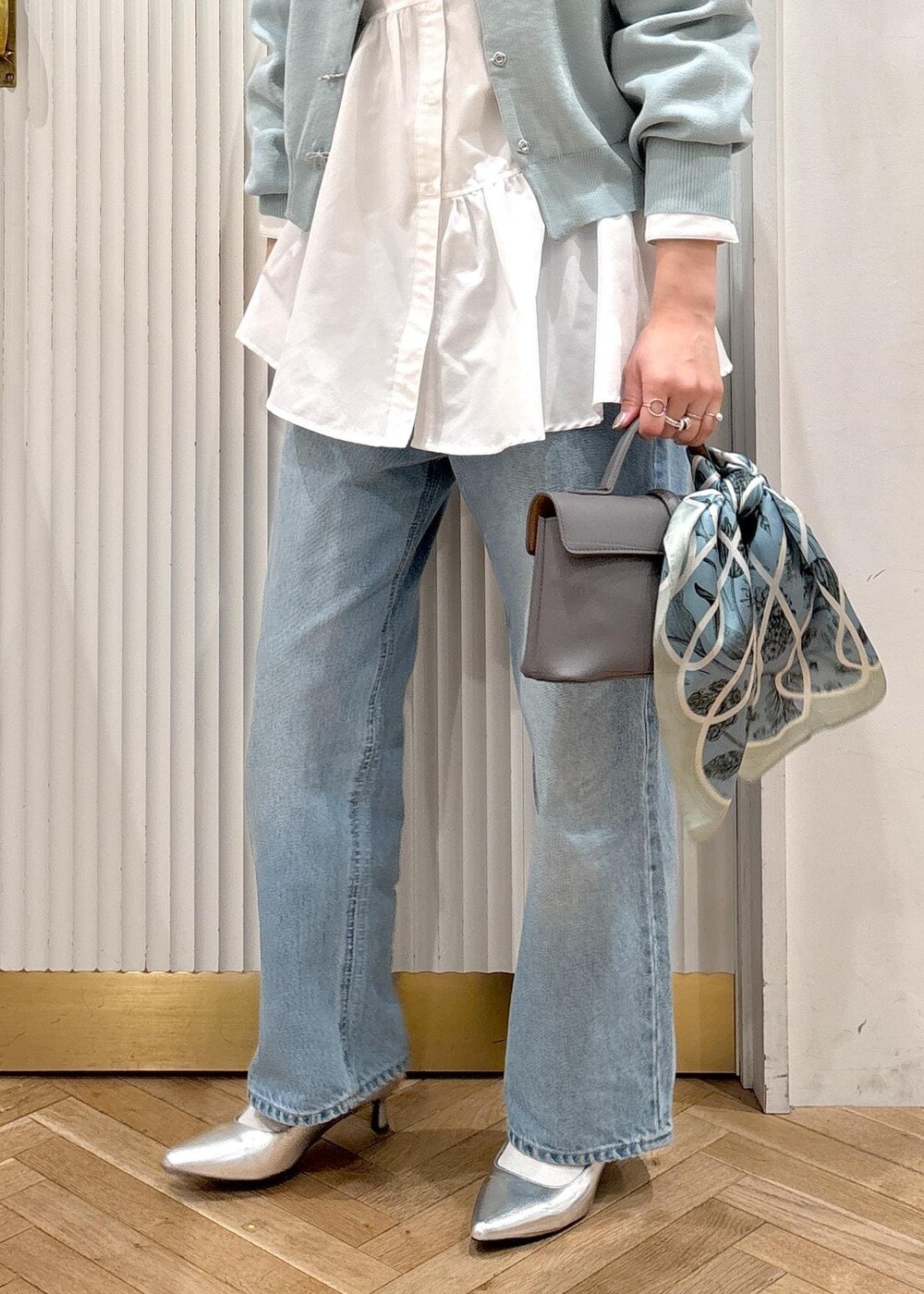 ホワイト系のシャツ/ブラウス、グレー系のショルダーバッグ、シルバー系のパンプスを着用したレディースの冬コーディネートの3枚目の写真