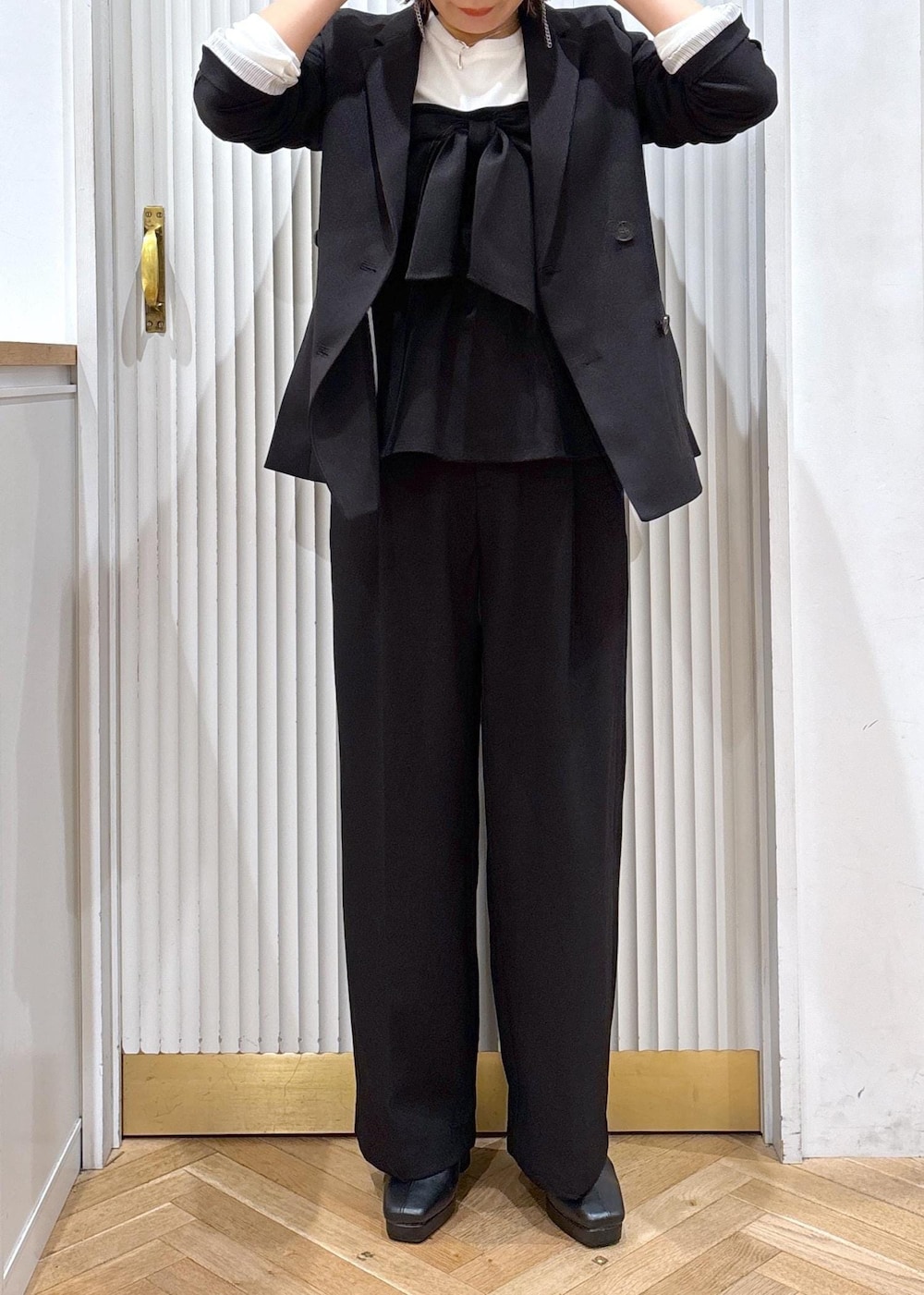 ブラック系のスラックス、ブラック系のテーラードジャケット、ブラック系のブーツを着用したレディースの秋コーディネートの8枚目の写真