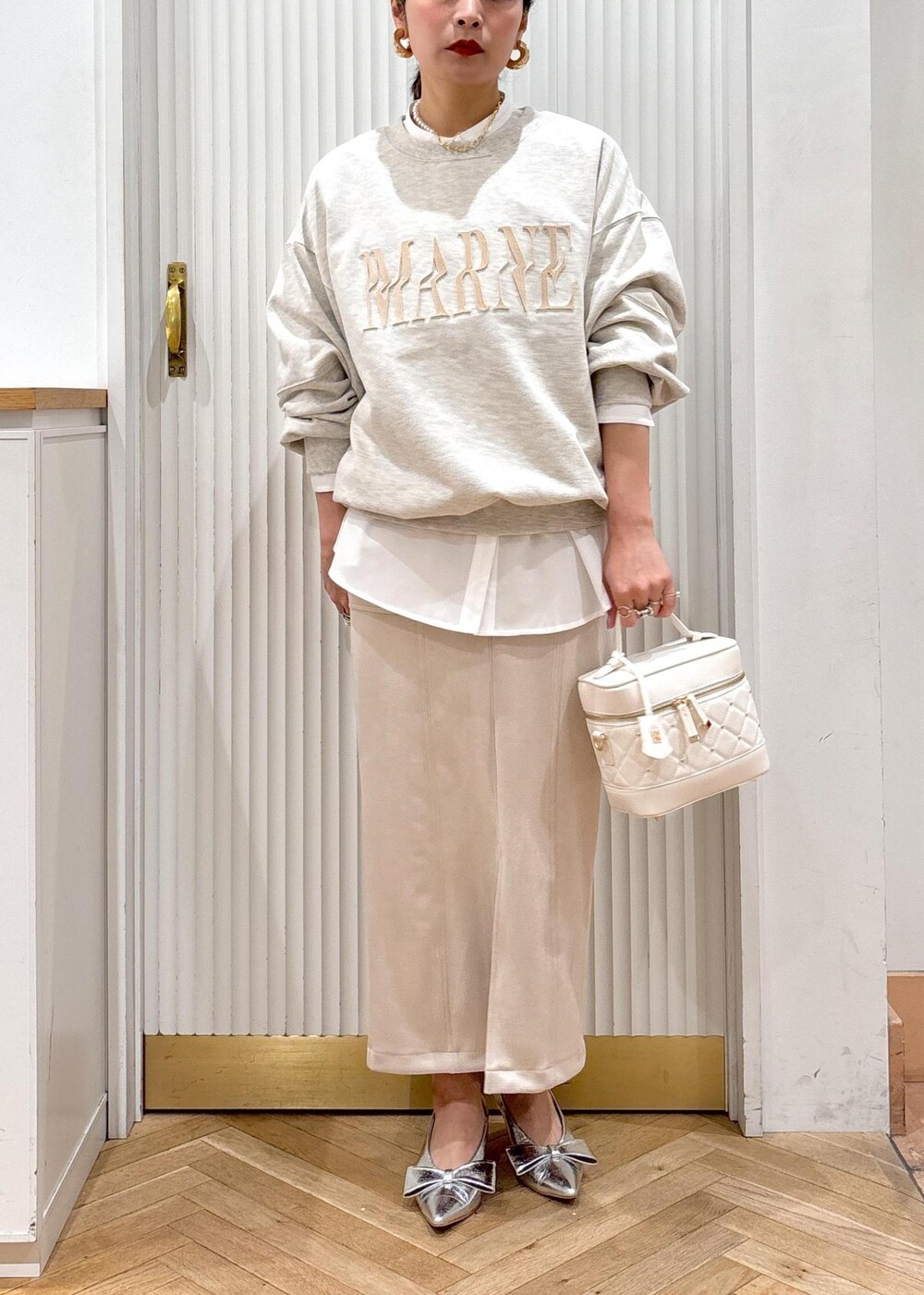シルバー系のパンプス、ホワイト系のスウェット、ホワイト系のシャツ/ブラウスを着用したレディースの冬コーディネートの9枚目の写真
