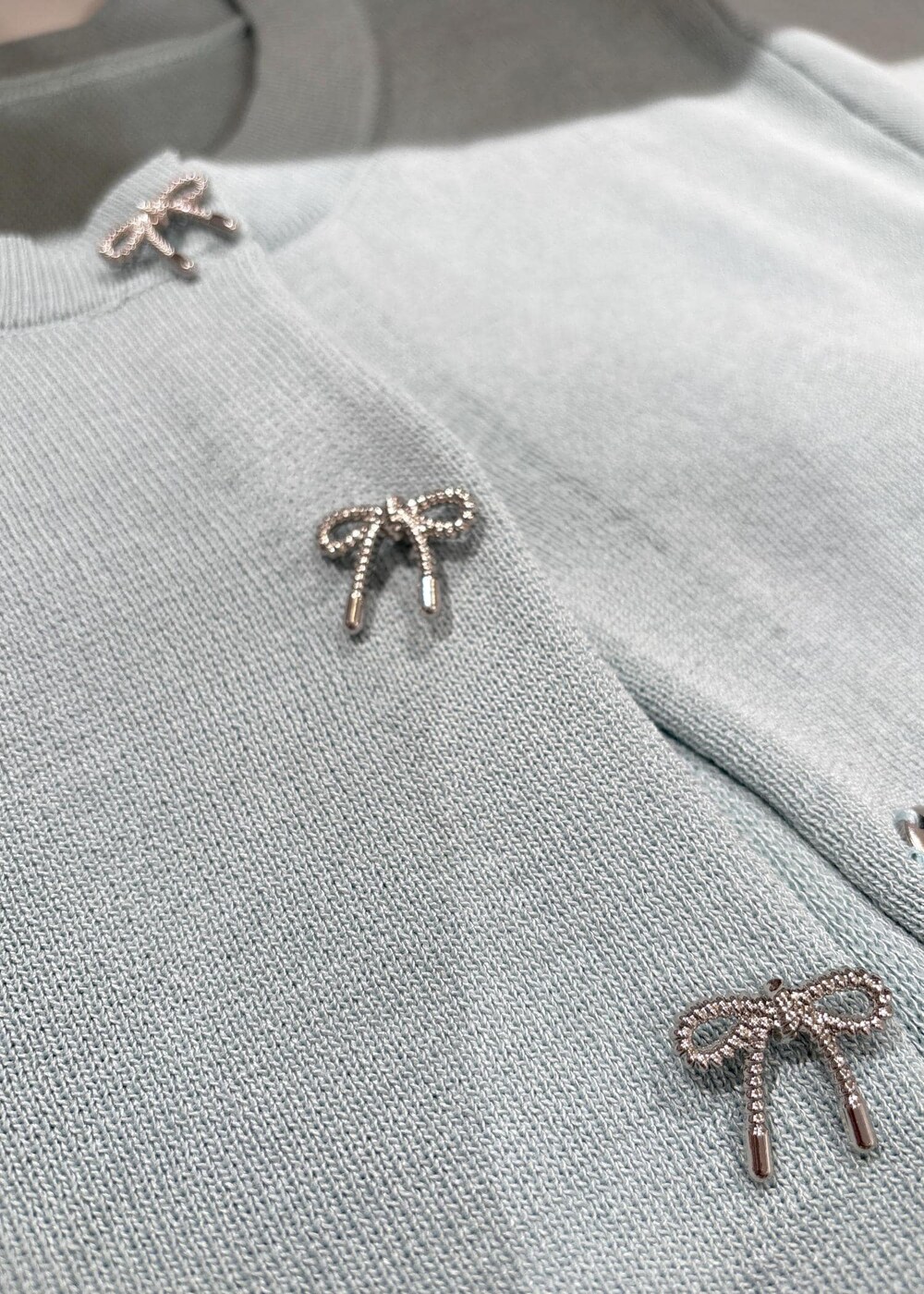 ホワイト系のシャツ/ブラウス、グレー系のショルダーバッグ、シルバー系のパンプスを着用したレディースの冬コーディネートの10枚目の写真