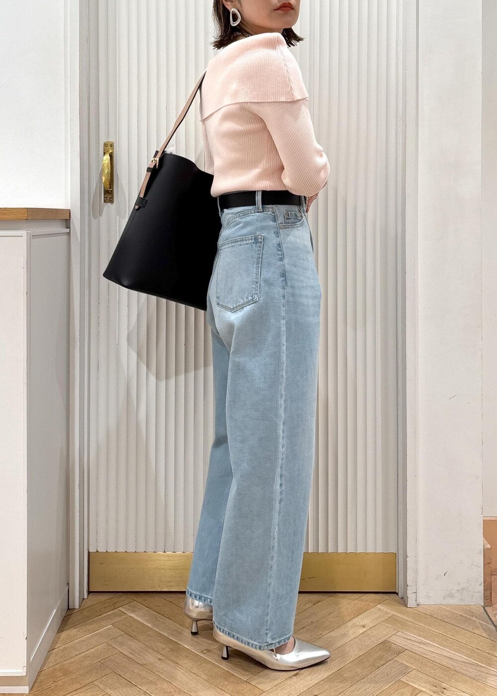 ブルー系のデニムパンツ、ブラック系のトートバッグ、ピンク系のニット/セーターを着用したレディースの春コーディネートの6枚目の写真