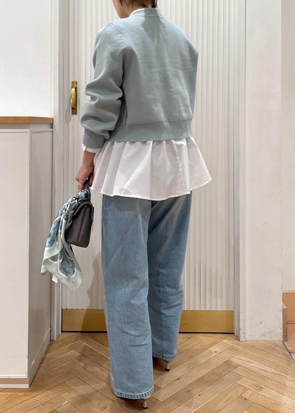 ホワイト系のシャツ/ブラウス、グレー系のショルダーバッグ、シルバー系のパンプスを着用したレディースの冬コーディネートの7枚目の写真