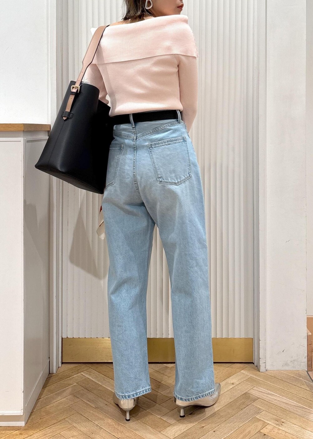 ブルー系のデニムパンツ、ブラック系のトートバッグ、ピンク系のニット/セーターを着用したレディースの春コーディネートの5枚目の写真