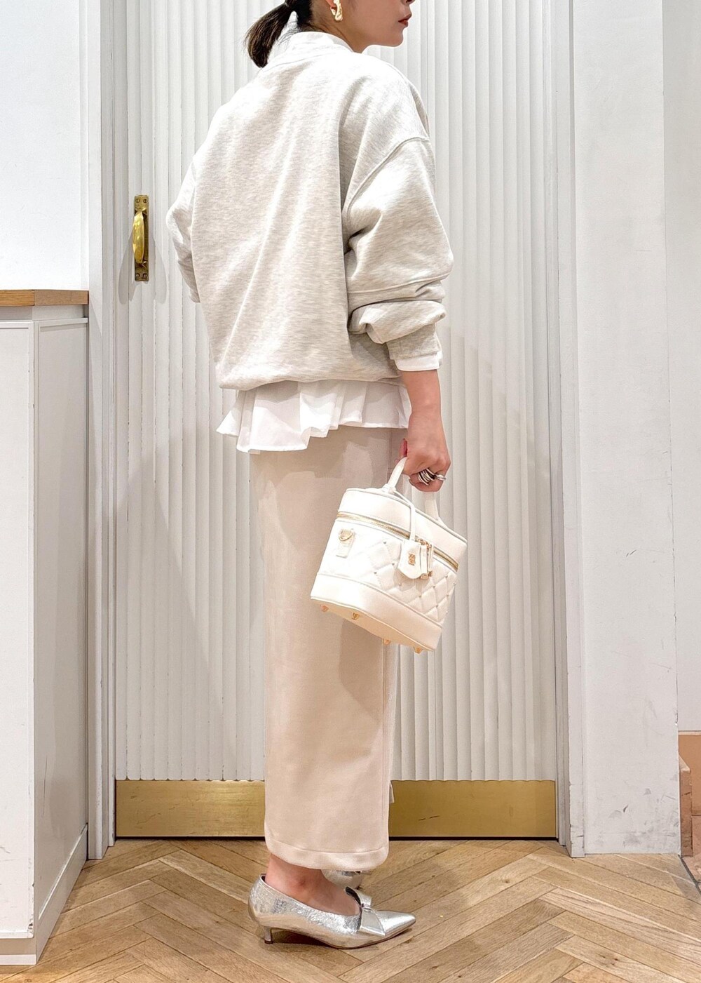 シルバー系のパンプス、ホワイト系のスウェット、ホワイト系のシャツ/ブラウスを着用したレディースの冬コーディネートの6枚目の写真