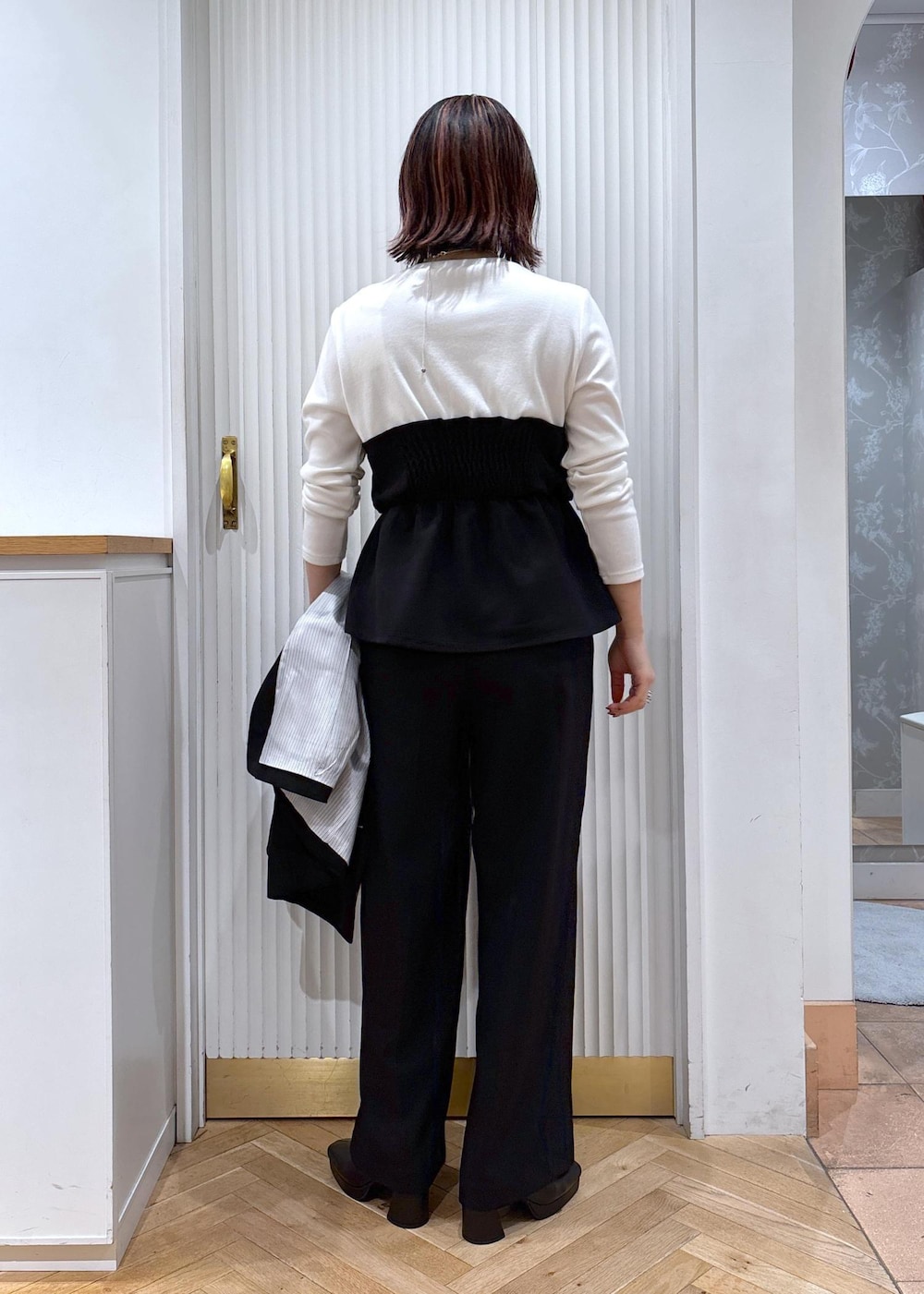 ブラック系のスラックス、ブラック系のテーラードジャケット、ブラック系のブーツを着用したレディースの秋コーディネートの10枚目の写真