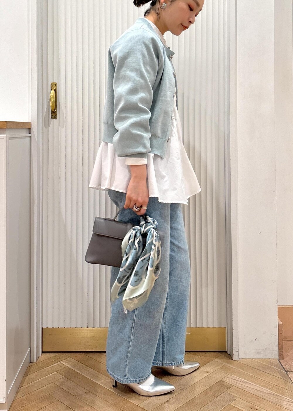 ホワイト系のシャツ/ブラウス、グレー系のショルダーバッグ、シルバー系のパンプスを着用したレディースの冬コーディネートの9枚目の写真