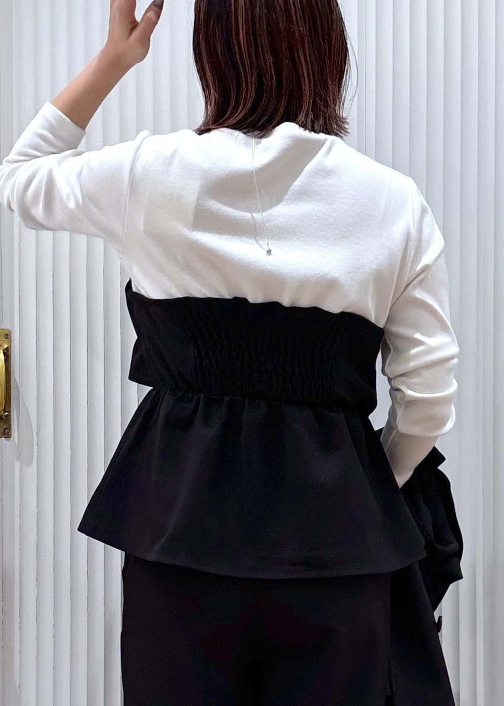 ブラック系のスラックス、ブラック系のテーラードジャケット、ブラック系のブーツを着用したレディースの秋コーディネートの9枚目の写真