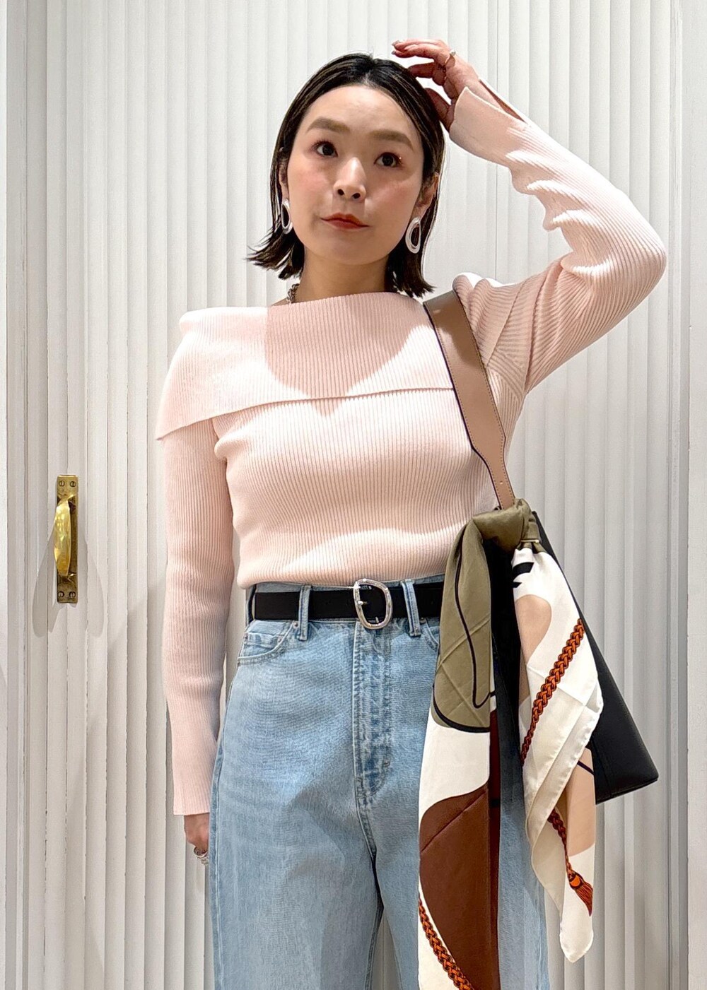 ブルー系のデニムパンツ、ブラック系のトートバッグ、ピンク系のニット/セーターを着用したレディースの春コーディネートの8枚目の写真