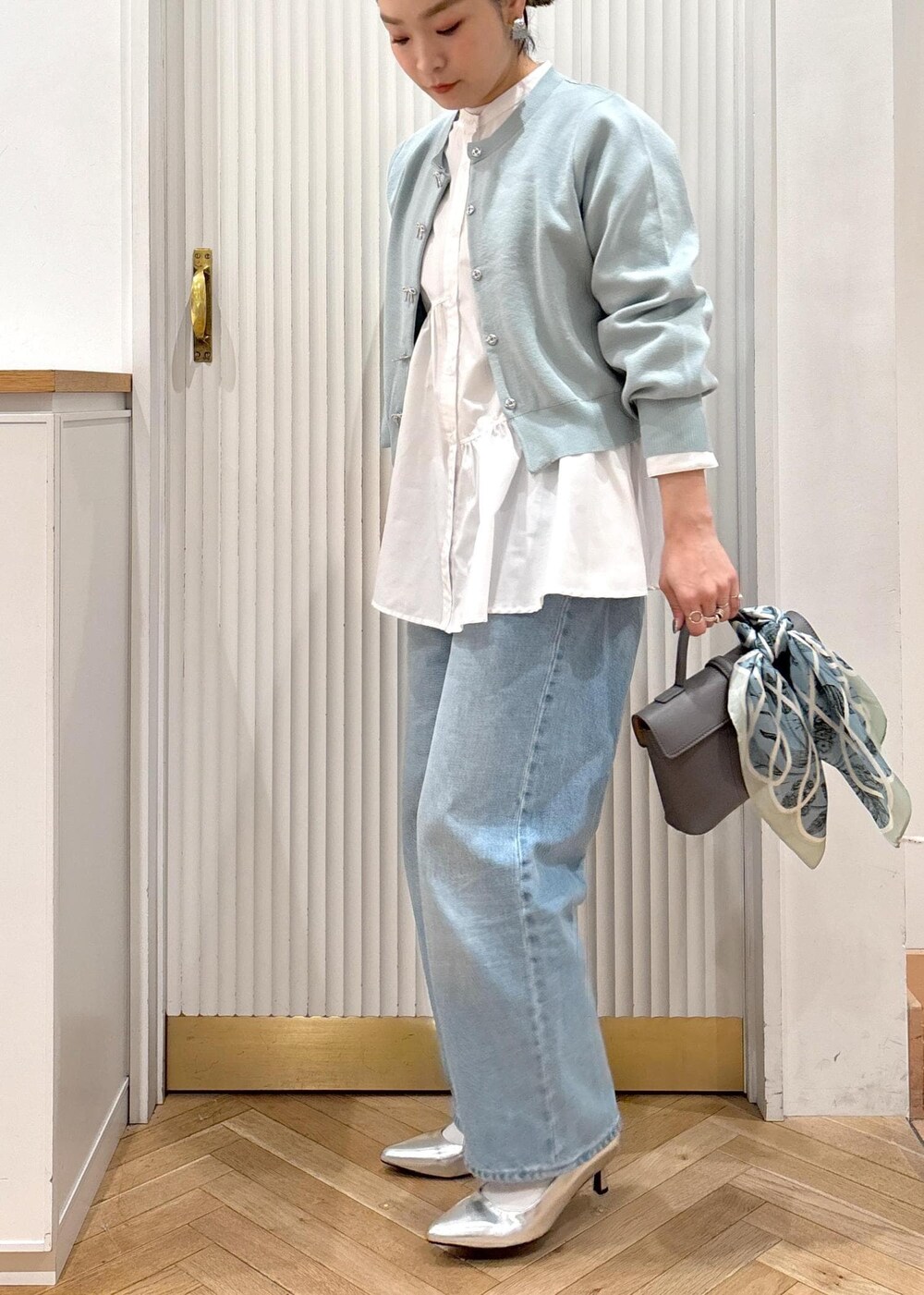 ホワイト系のシャツ/ブラウス、グレー系のショルダーバッグ、シルバー系のパンプスを着用したレディースの冬コーディネートの4枚目の写真
