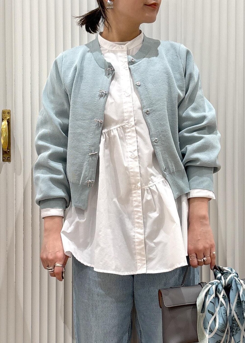 ホワイト系のシャツ/ブラウス、グレー系のショルダーバッグ、シルバー系のパンプスを着用したレディースの冬コーディネートの2枚目の写真