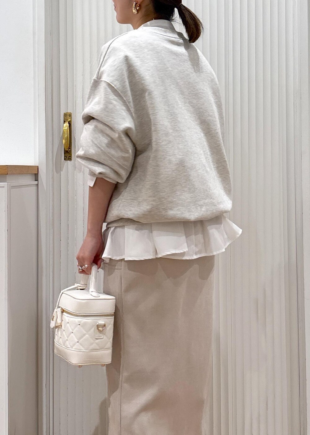 シルバー系のパンプス、ホワイト系のスウェット、ホワイト系のシャツ/ブラウスを着用したレディースの冬コーディネートの3枚目の写真
