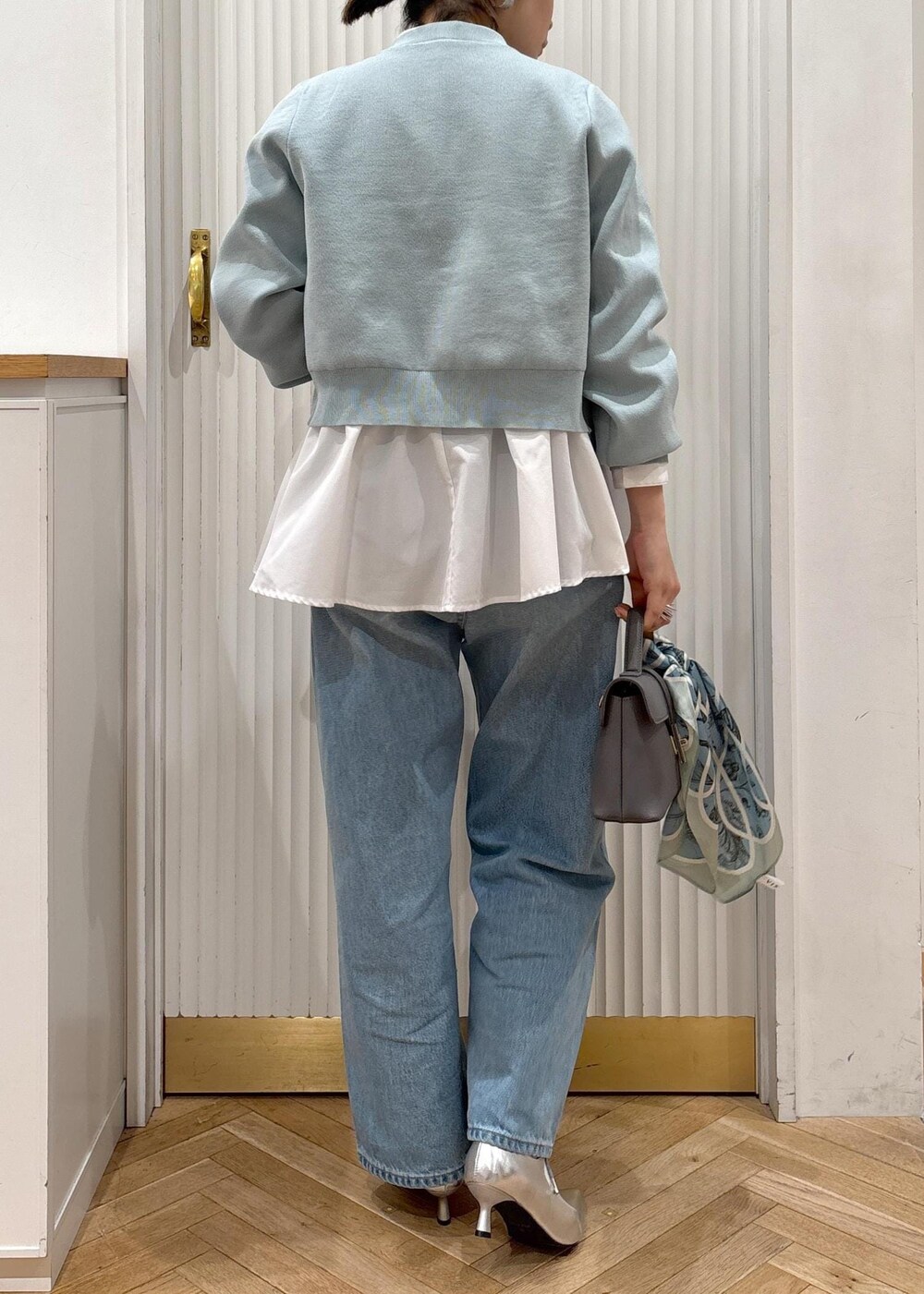 ホワイト系のシャツ/ブラウス、グレー系のショルダーバッグ、シルバー系のパンプスを着用したレディースの冬コーディネートの8枚目の写真