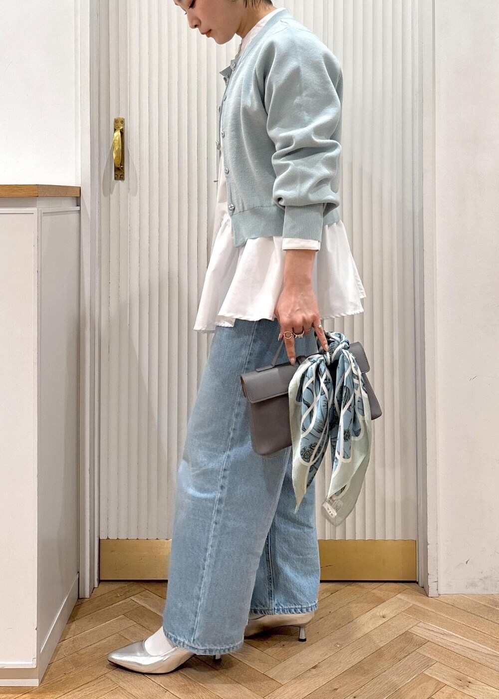 ホワイト系のシャツ/ブラウス、グレー系のショルダーバッグ、シルバー系のパンプスを着用したレディースの冬コーディネートの6枚目の写真