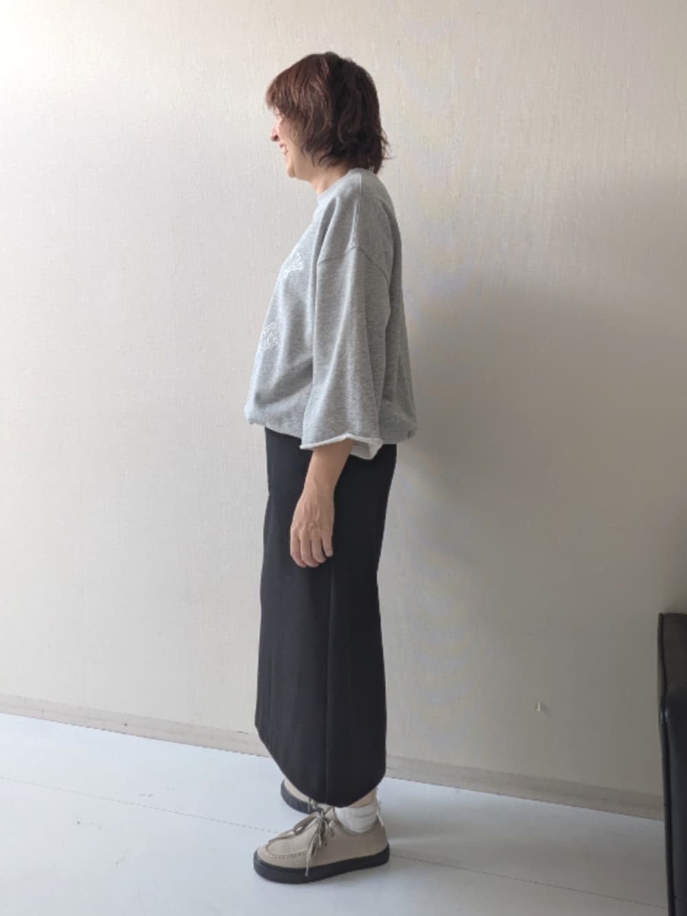 ブラウン系のスニーカー、ブラック系のニット/セーター、ブラック系のベストを着用したレディースの秋コーディネートの6枚目の写真