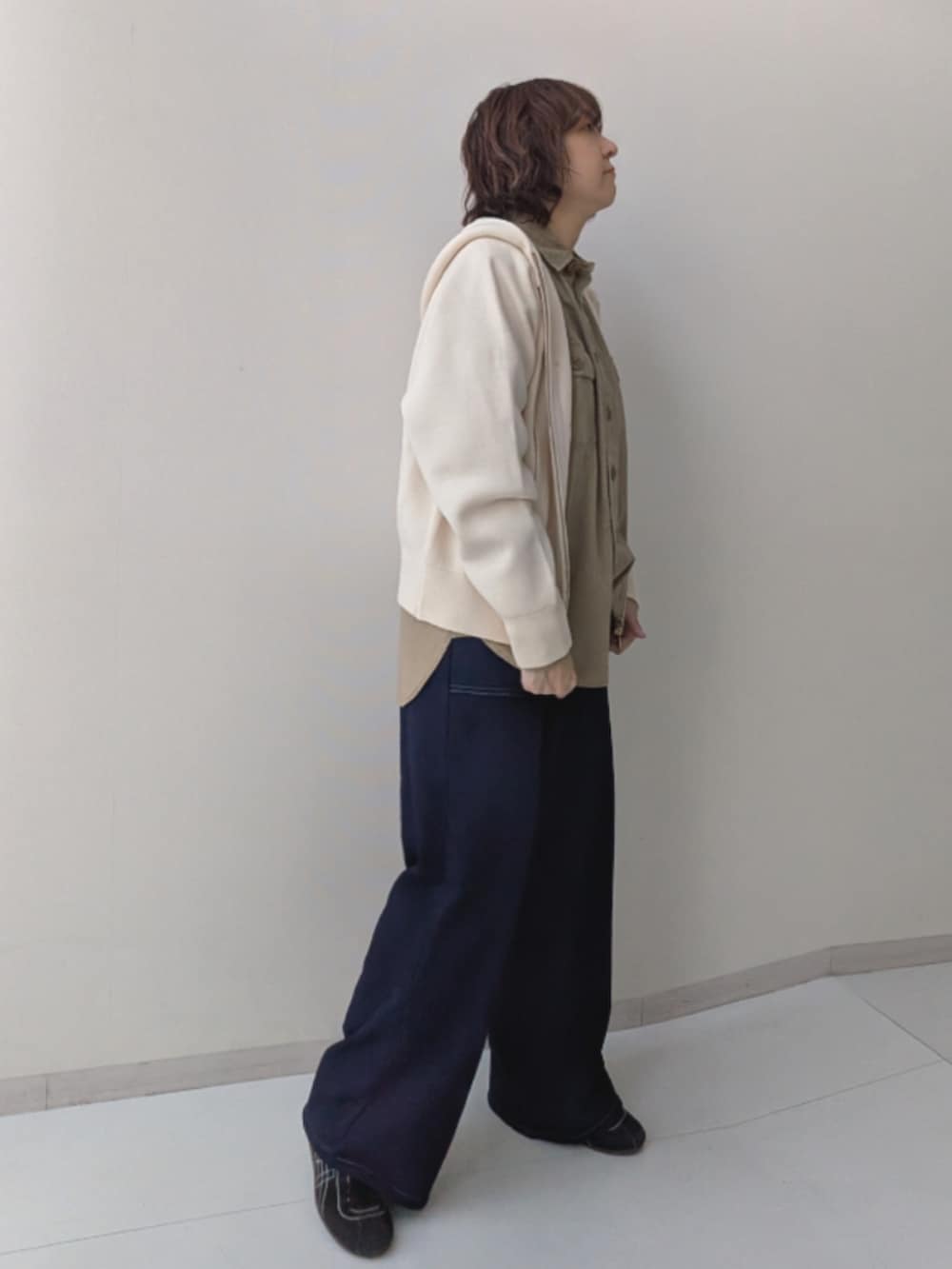 ベージュ系のシャツ/ブラウス、ブラウン系のカバーオール、ブルー系のデニムパンツを着用したレディースの秋コーディネートの7枚目の写真