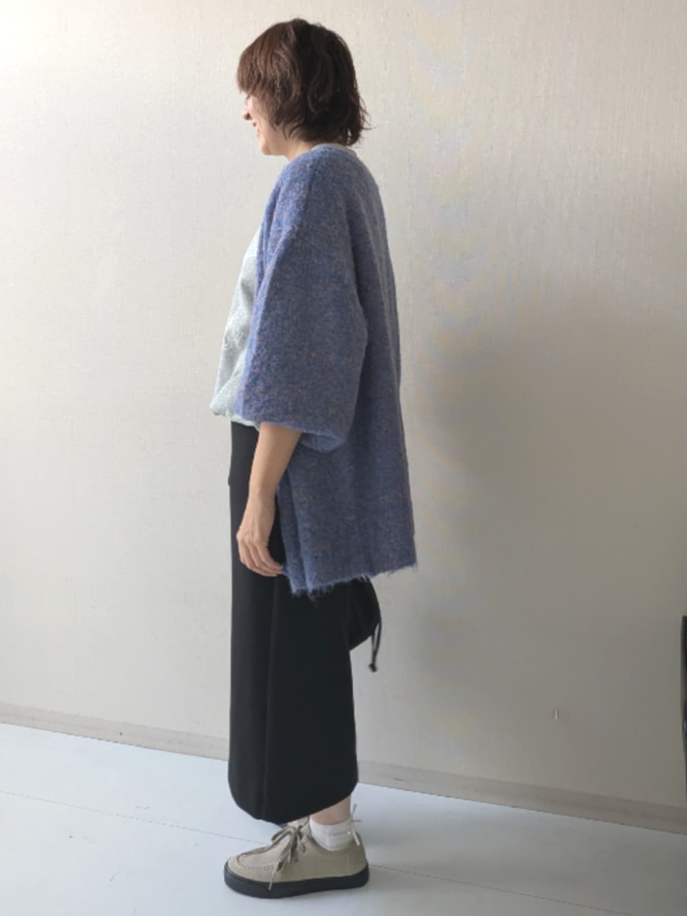 ブラウン系のスニーカー、ブラック系のニット/セーター、ブラック系のベストを着用したレディースの秋コーディネートの8枚目の写真