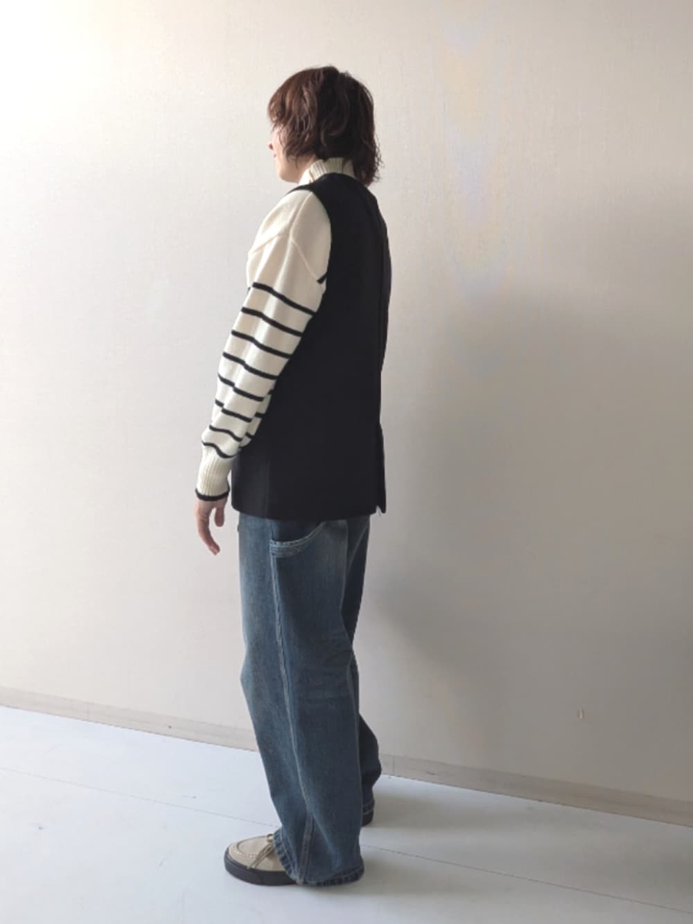 ブラウン系のスニーカー、ブラック系のニット/セーター、ブラック系のベストを着用したレディースの秋コーディネートの10枚目の写真