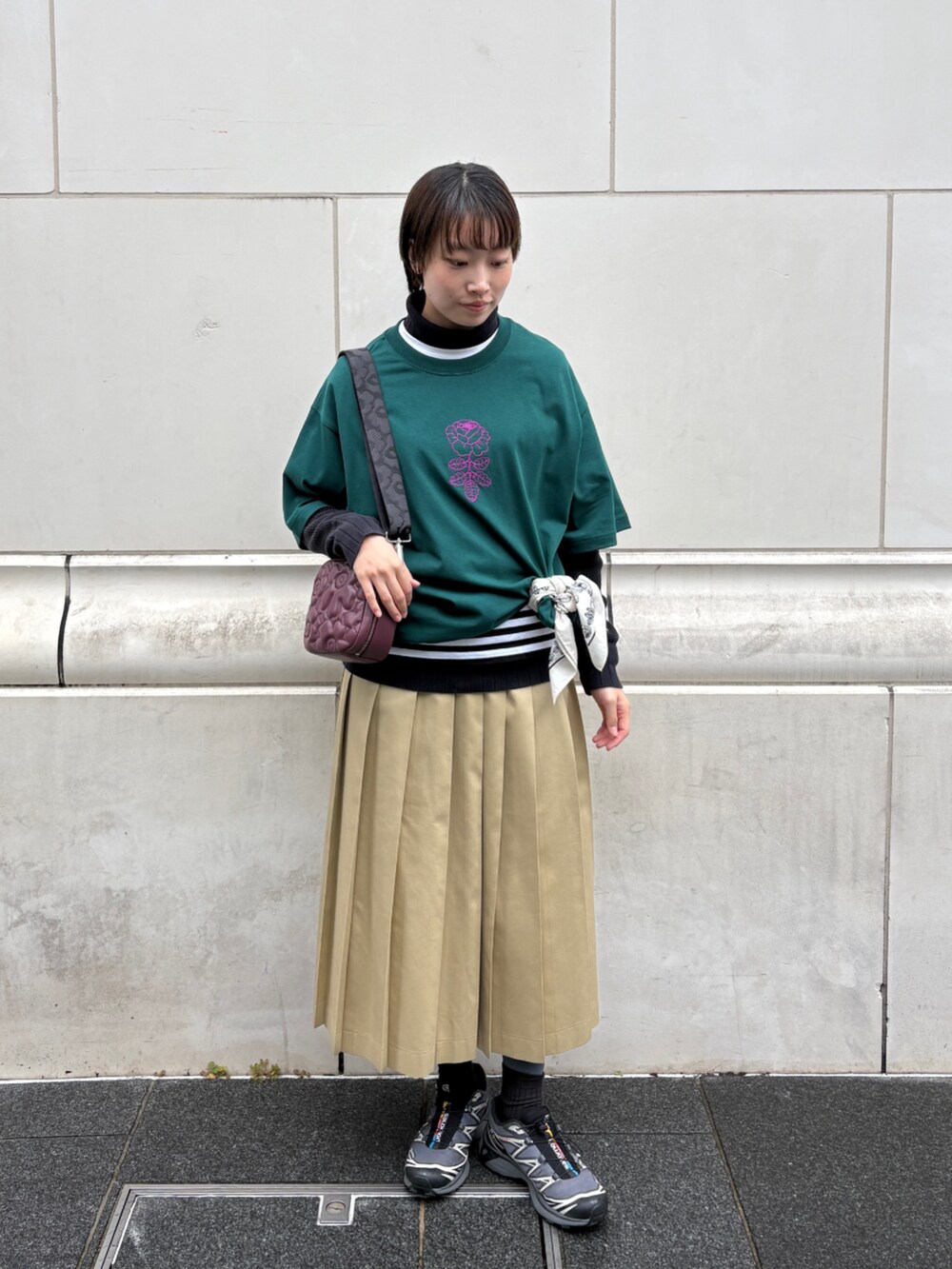 レッド系のショルダーバッグ、グリーン系のTシャツ/カットソー、ホワイト系のストール/ショールを着用したレディースの冬コーディネートの2枚目の写真