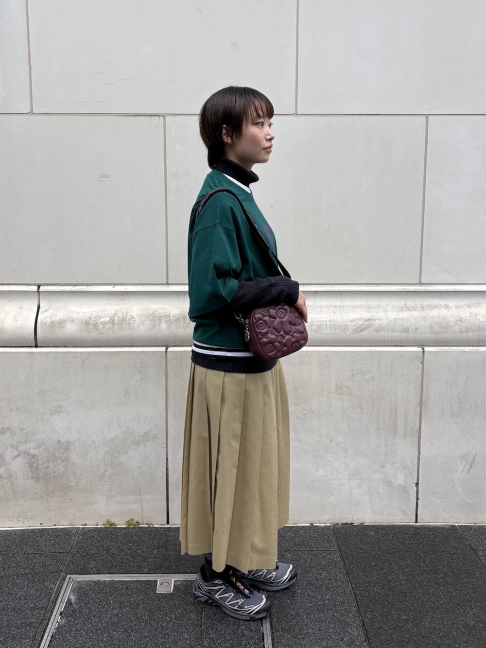 レッド系のショルダーバッグ、グリーン系のTシャツ/カットソー、ホワイト系のストール/ショールを着用したレディースの冬コーディネートの3枚目の写真