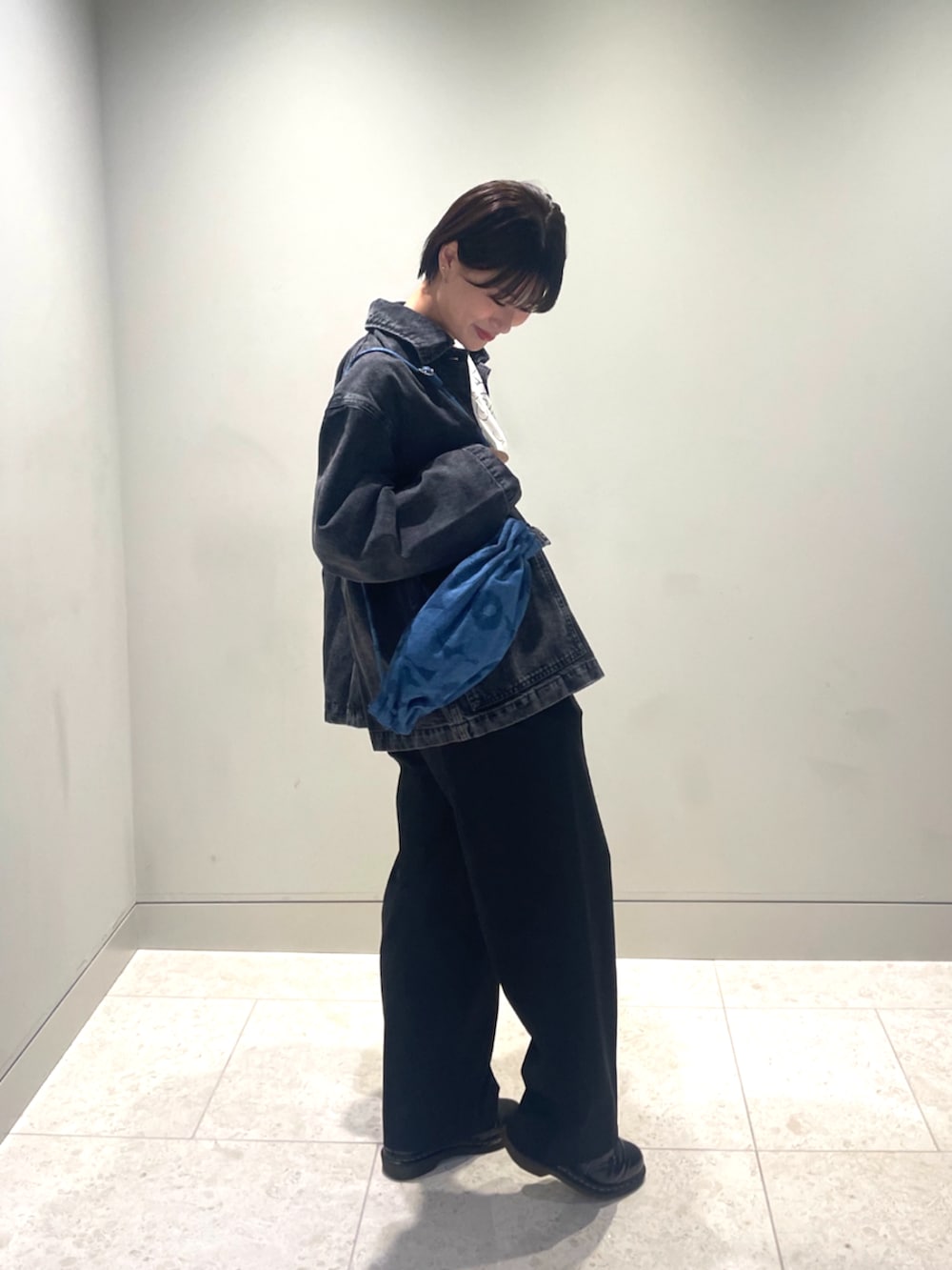 ブルー系のショルダーバッグ、ブラック系のデニムジャケット、ホワイト系のTシャツ/カットソーを着用したレディースの秋コーディネートの5枚目の写真