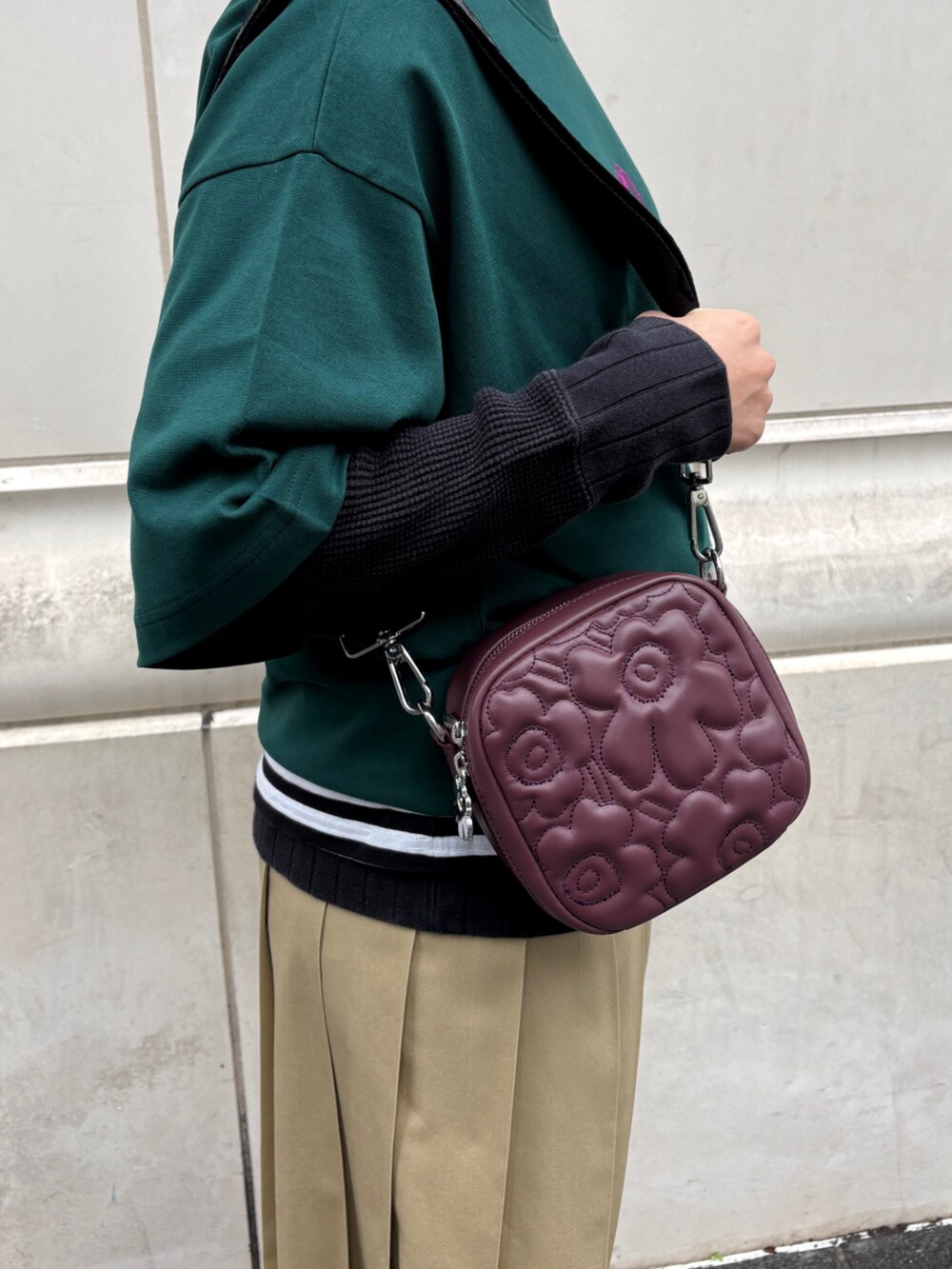レッド系のショルダーバッグ、グリーン系のTシャツ/カットソー、ホワイト系のストール/ショールを着用したレディースの冬コーディネートの6枚目の写真