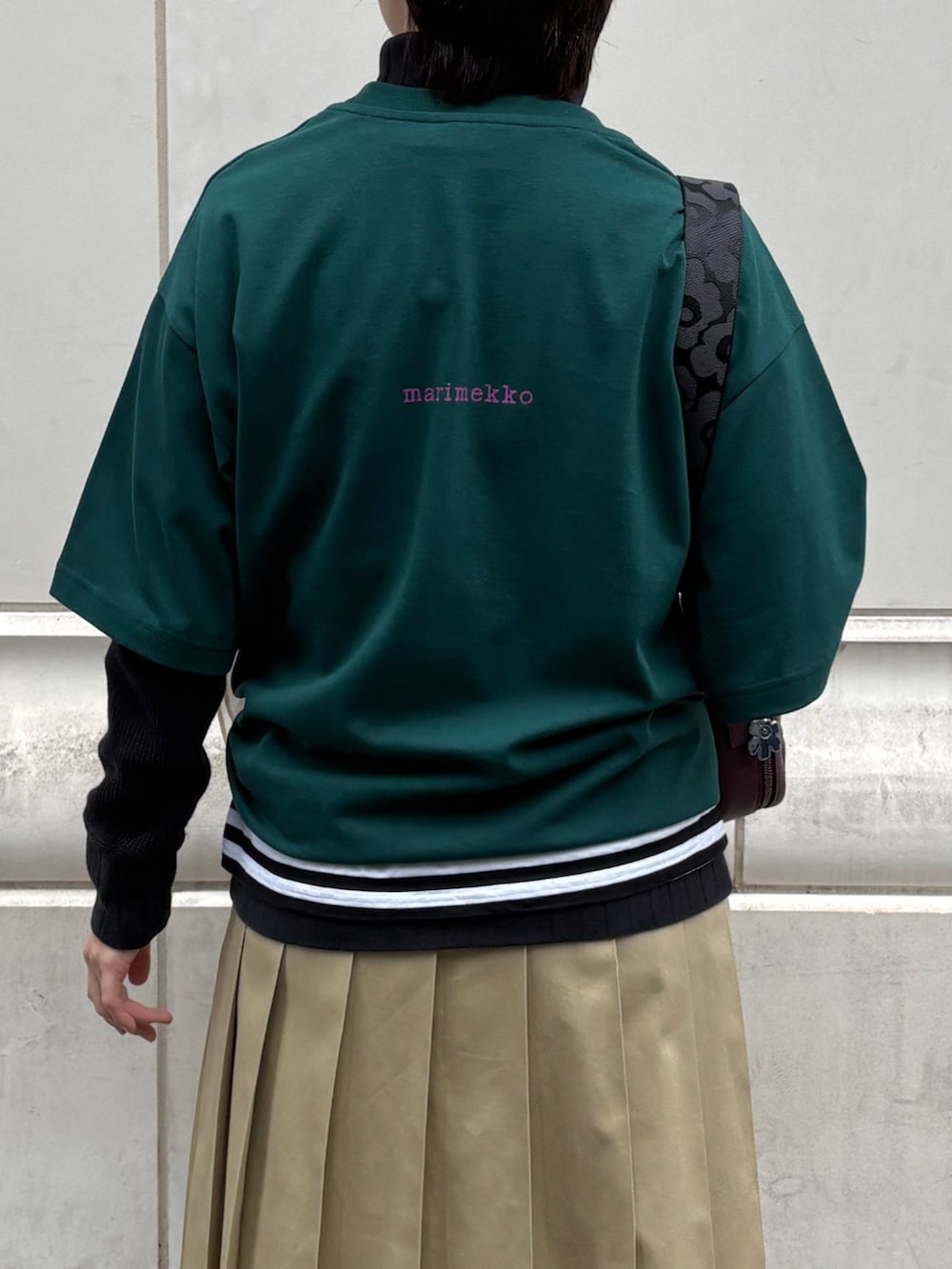 レッド系のショルダーバッグ、グリーン系のTシャツ/カットソー、ホワイト系のストール/ショールを着用したレディースの冬コーディネートの5枚目の写真