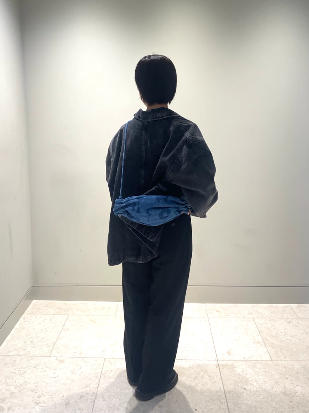 ブルー系のショルダーバッグ、ブラック系のデニムジャケット、ホワイト系のTシャツ/カットソーを着用したレディースの秋コーディネートの4枚目の写真