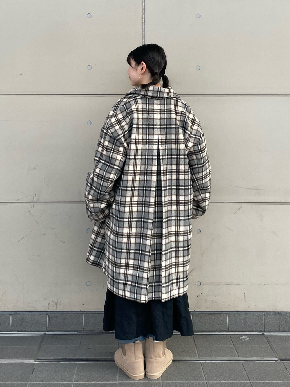 ベージュ系のブーツ、ブラック系のワンピース、ホワイト系のTシャツ/カットソーを着用したレディースの冬コーディネートの2枚目の写真