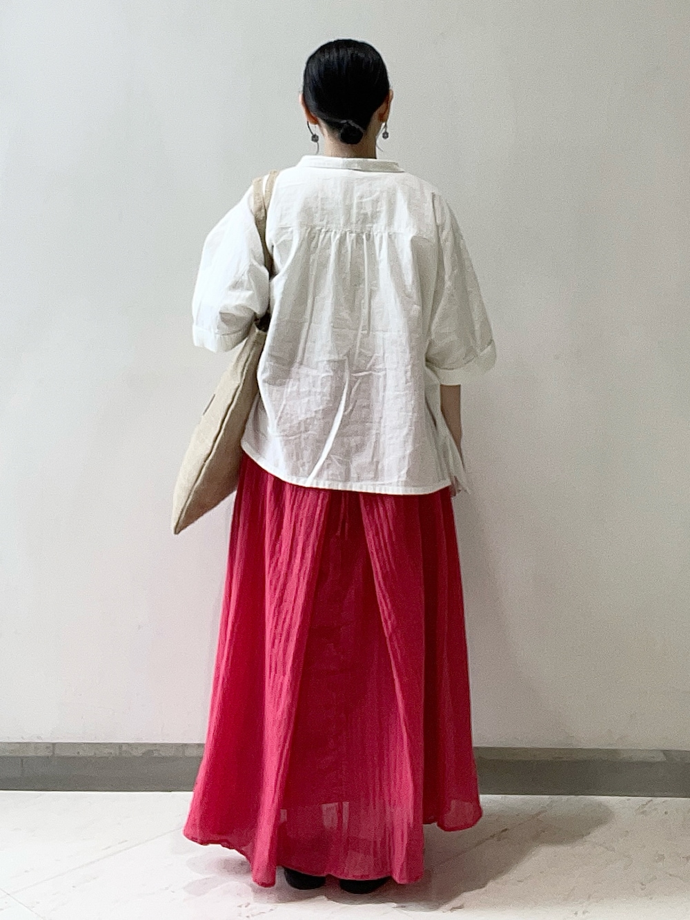 ホワイト系のTシャツ/カットソー、レッド系のワンピース、ブラック系のサンダルを着用したレディースの冬コーディネートの2枚目の写真