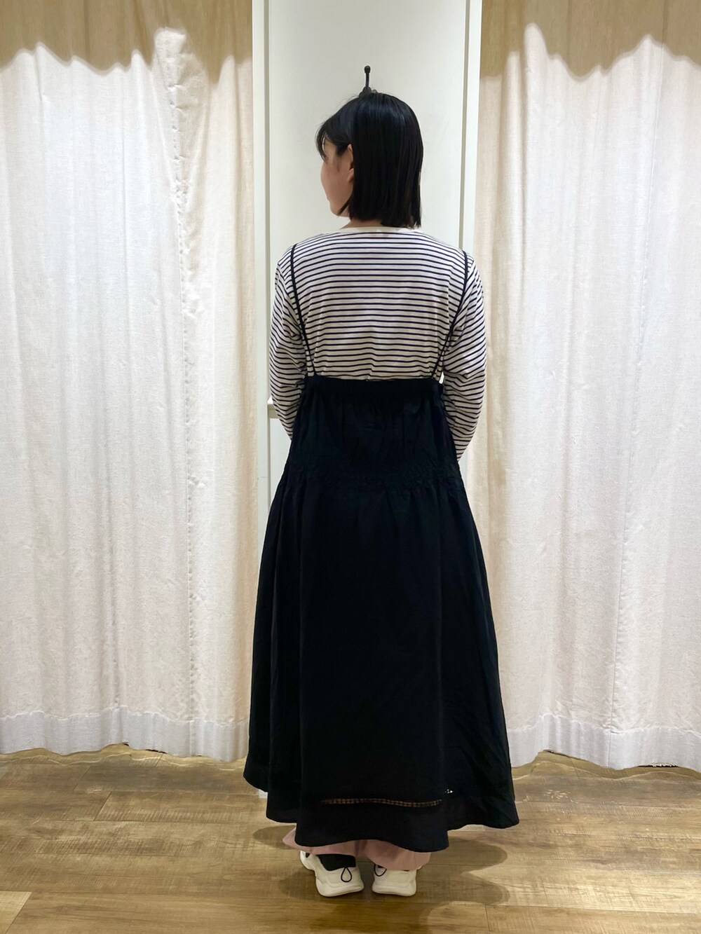 グレー系のTシャツ/カットソー、ピンク系のハンドバッグ、ブラック系のスニーカーを着用したレディースの春コーディネートの2枚目の写真